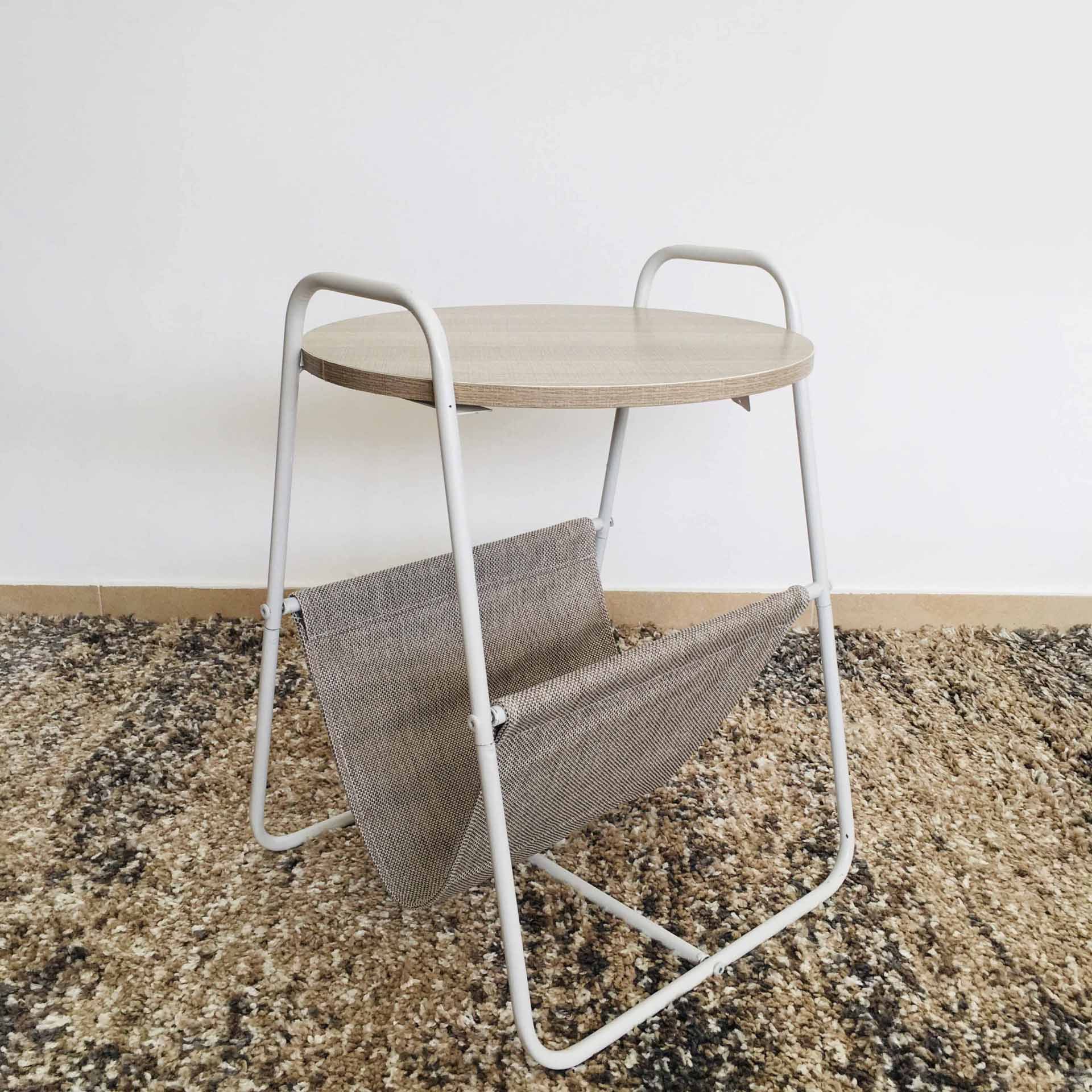 Mesa auxiliar redonda madeira clara com estrutura metálica branca e suporte tecido bege