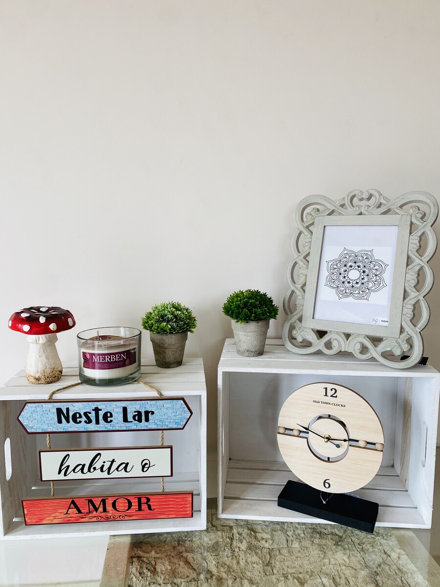 Decoração com caixotes de madeira branca, plantas, vela, cogumelo decorativo e relógio