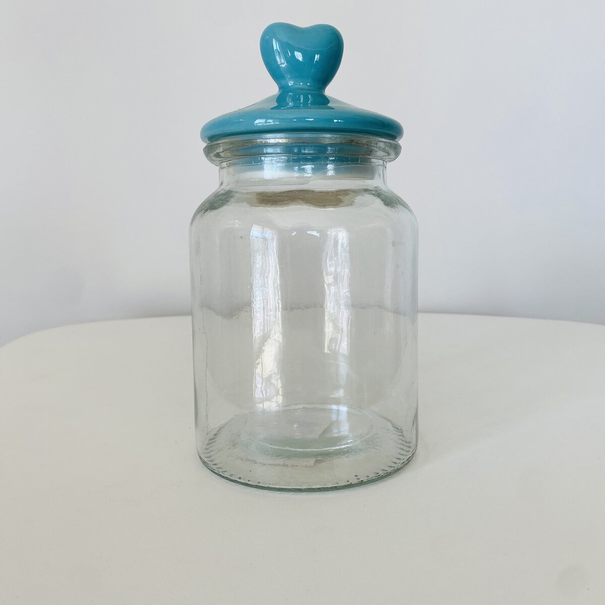 Frasco de vidro com tampa azul em formato de coração