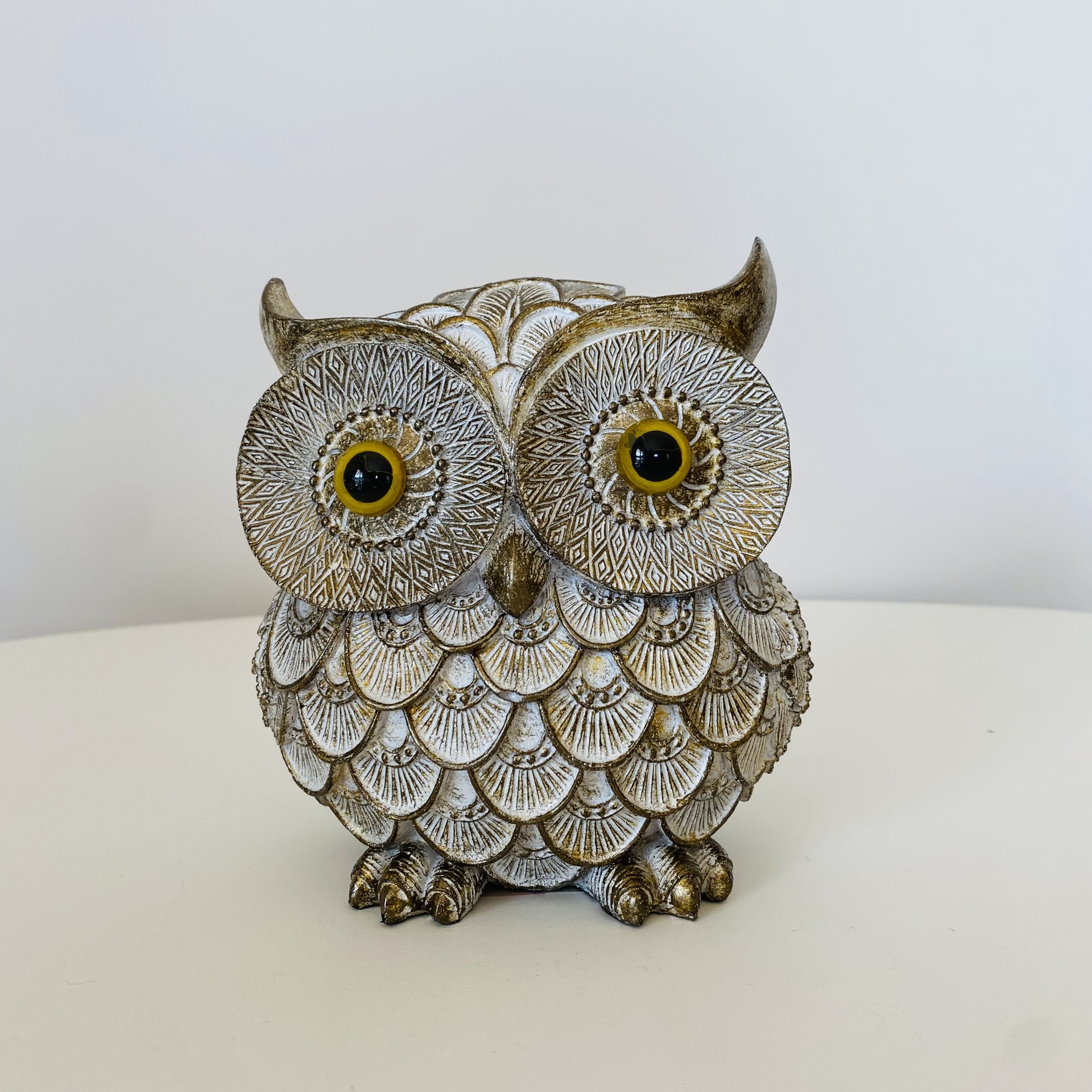 Estátua de coruja decorativa em tons bege e dourado