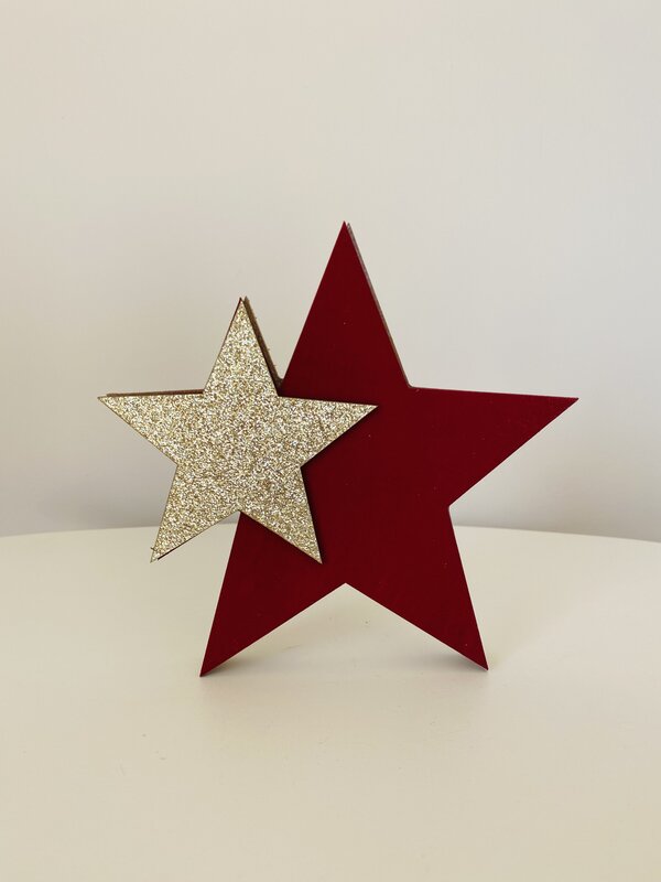 Duas estrelas decorativas, uma vermelha e outra dourada com glitter