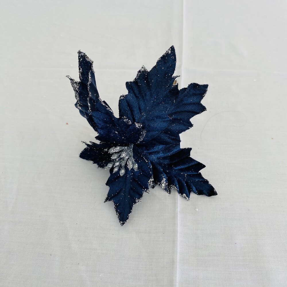 Flor decorativa artificial azul com brilho prateado em fundo branco