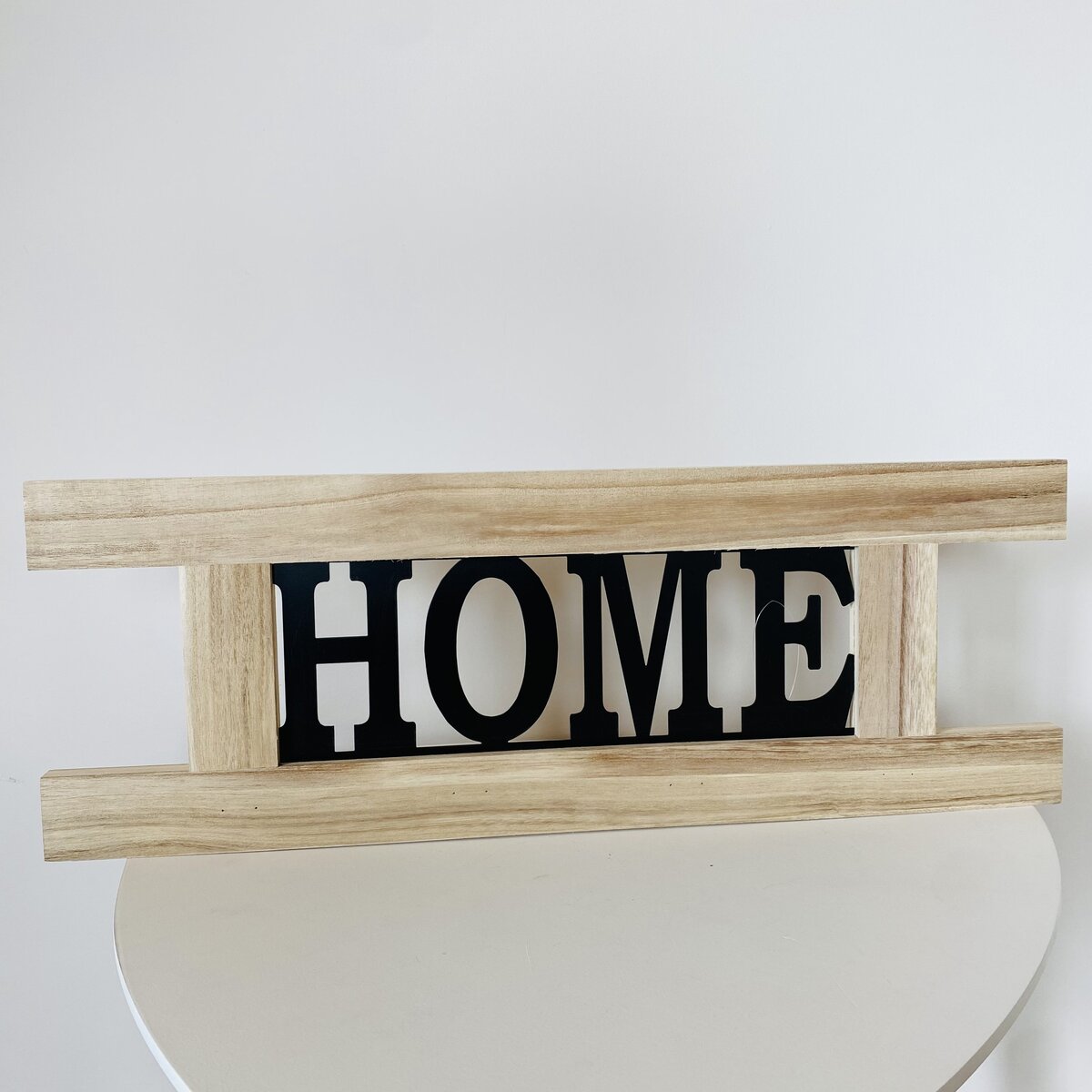 Decoração com palavra HOME em madeira clara e letras pretas