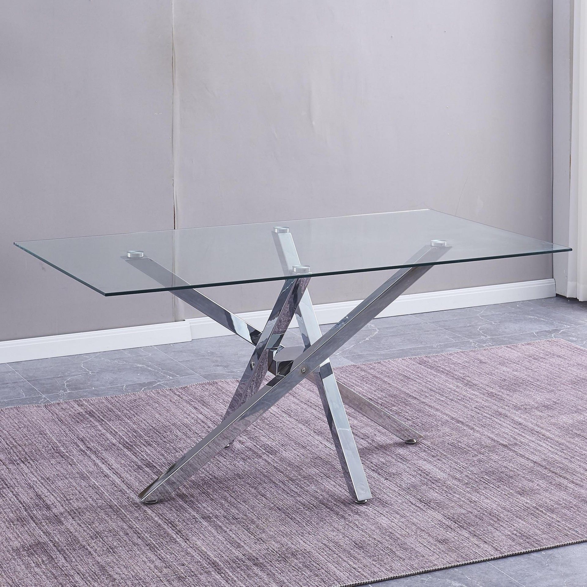 Mesa de centro de vidro com base metálica prateada sobre tapete roxo