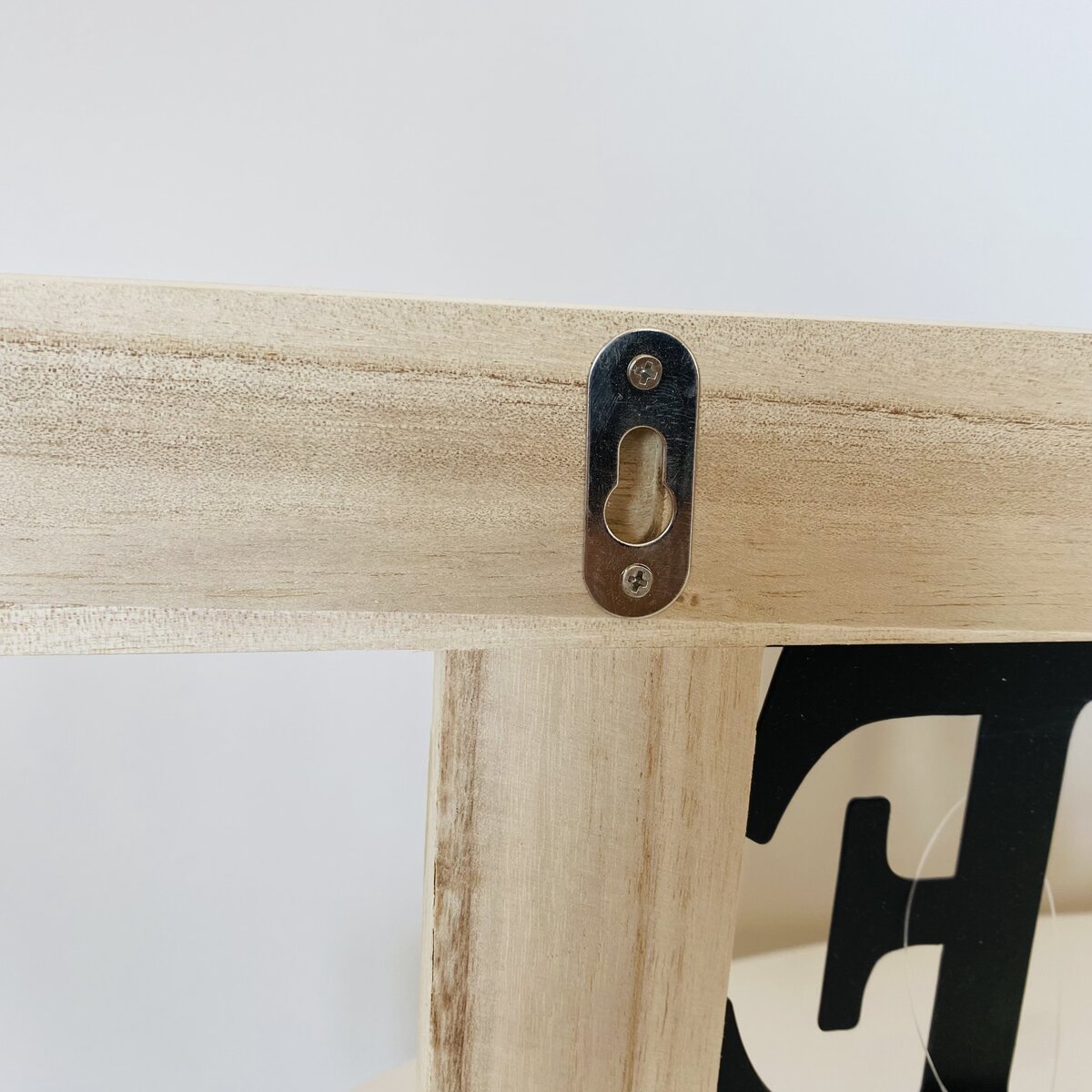 Estrutura de madeira clara com chapa metálica preta para pendurar na parede