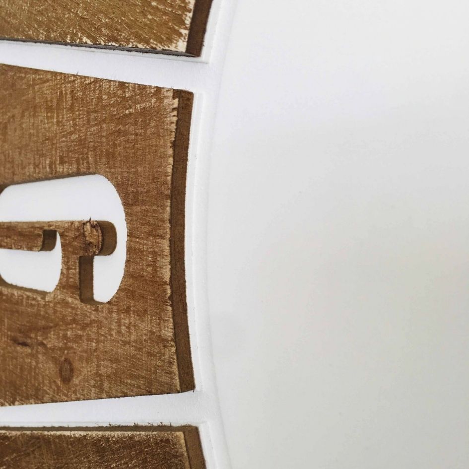 Placa decorativa de letras em madeira castanha clara sobre fundo branco