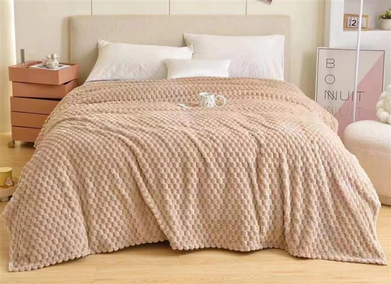 Colcha bege acolchoada em cama com cabeceira branca e decoração minimalista