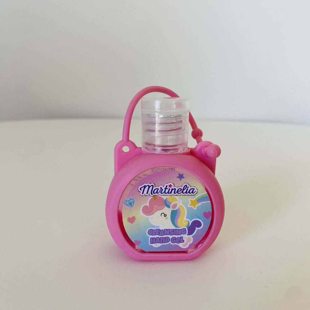 Pequeno frasco de gel desinfetante rosa com rótulo de unicórnio.