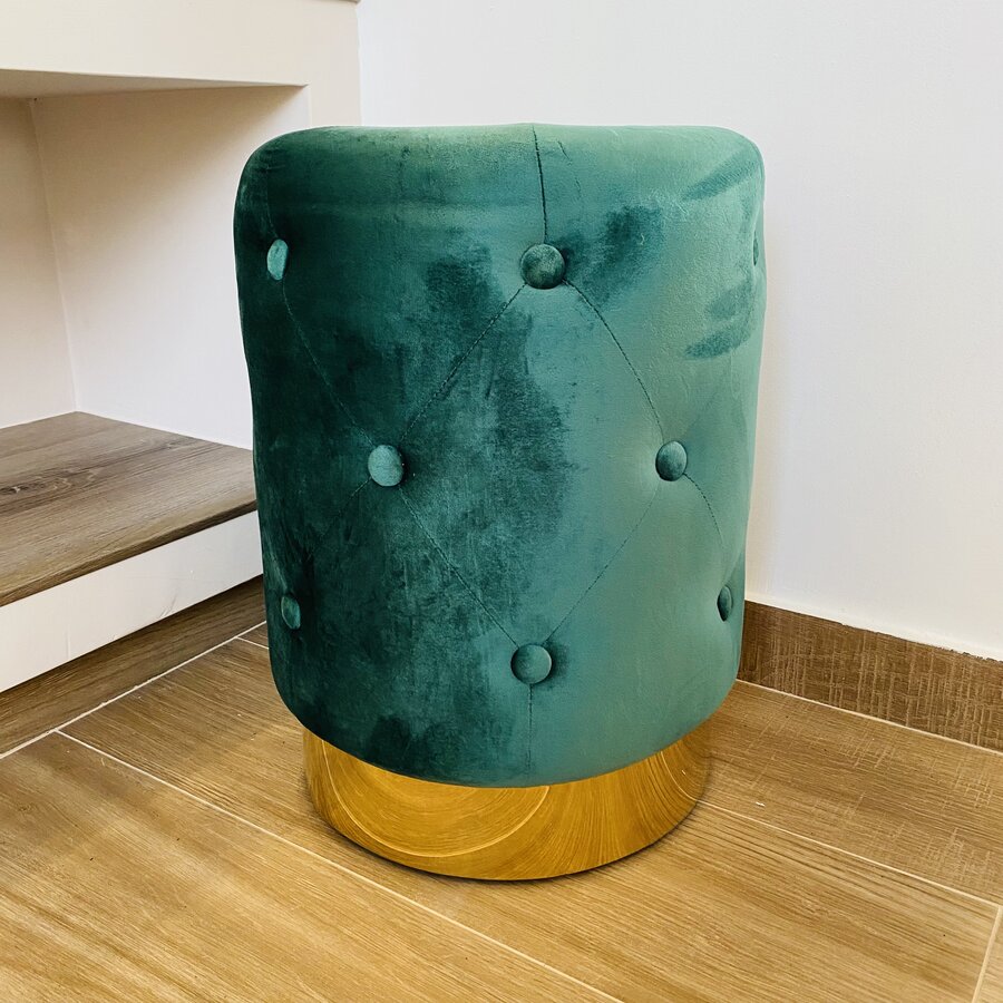 Banco redondo verde em veludo com base dourada no chão de madeira