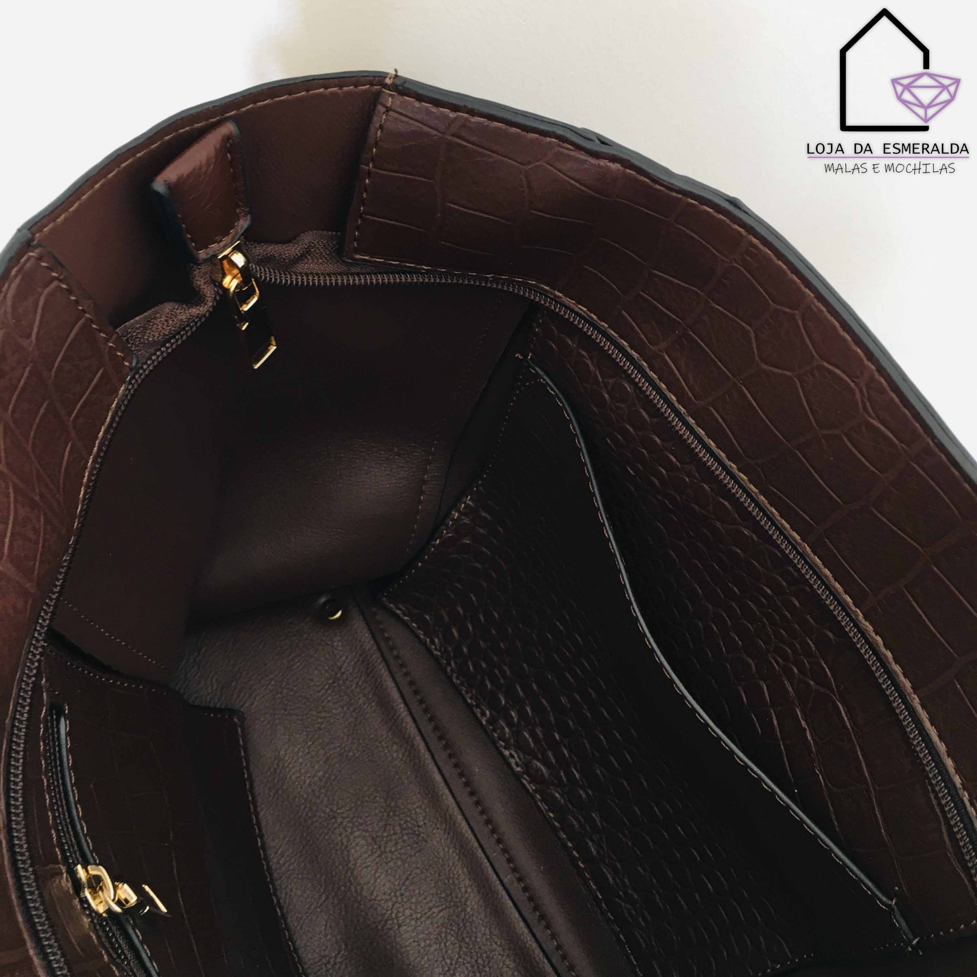 Interior de mala castanho escuro com textura de pele de crocodilo e fecho dourado