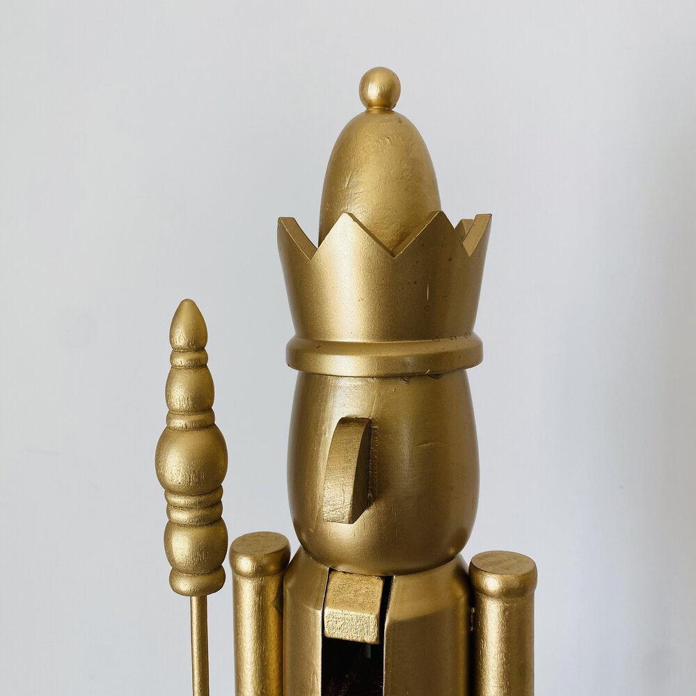 Estatueta dourada de rei com coroa e cetro sobre fundo branco