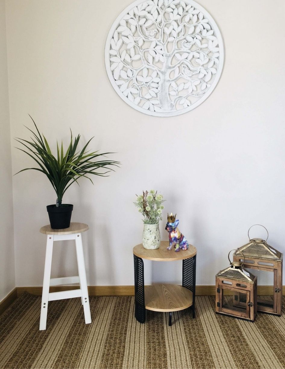 Conjunto de mobiliário e decoração com banco, mesa, vaso, estatueta de cão, lanternas e decoração de parede