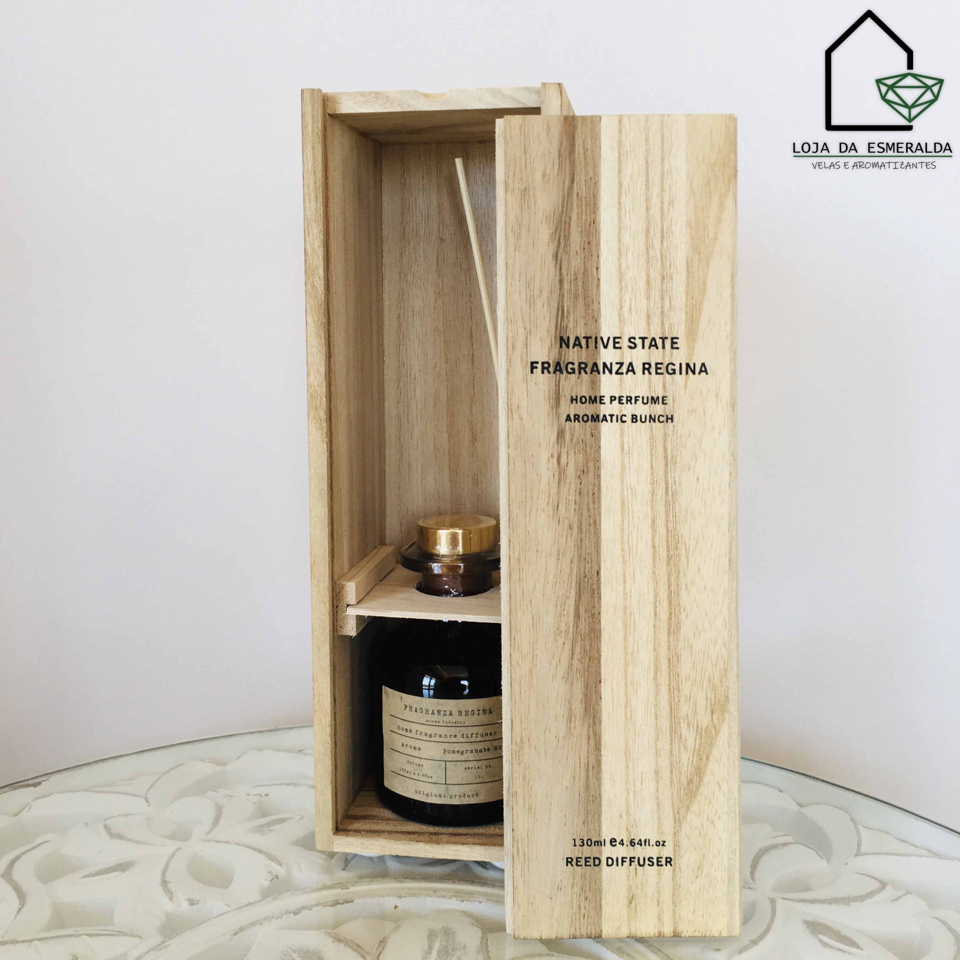 Caixa de madeira clara com frasco escuro e tampa dourada para ambientador de varetas