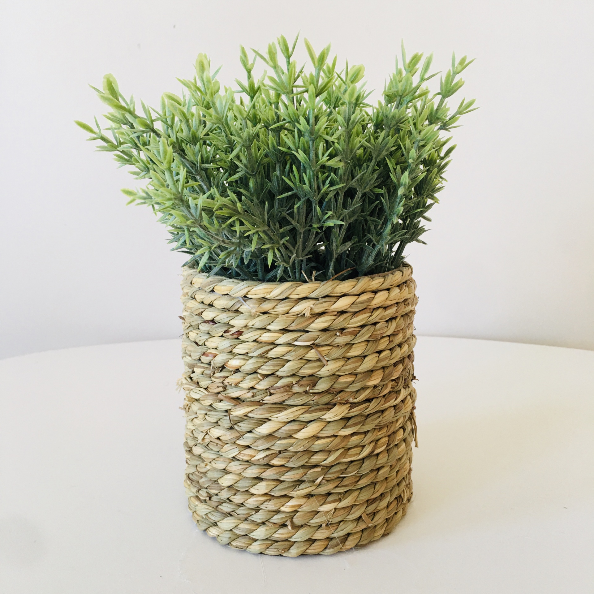 Planta artificial verde em vaso revestido de corda natural