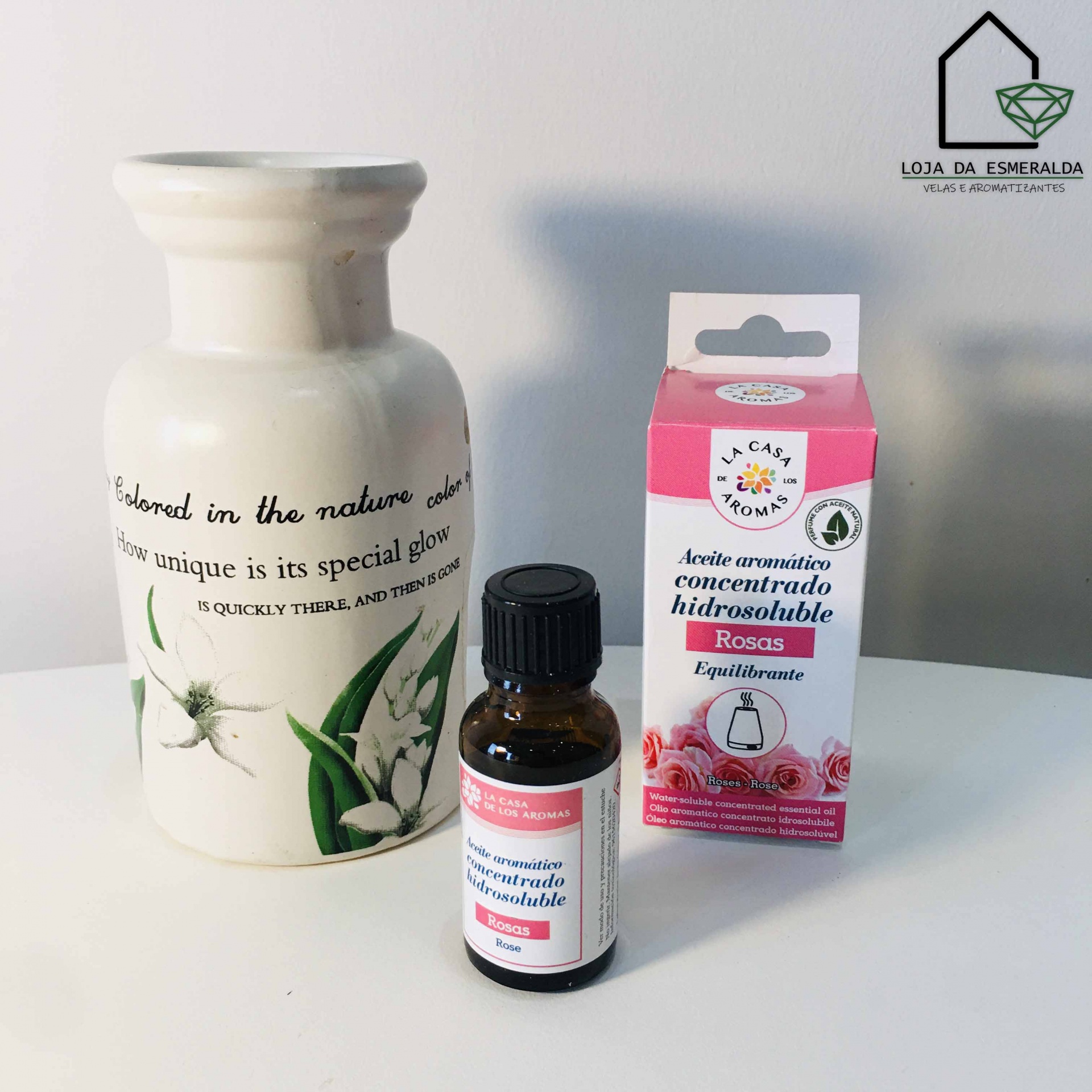 Frasco de óleo aromático com embalagem rosa e jarro cerâmico decorativo branco