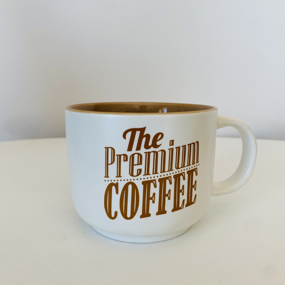 Caneca branca com texto castanho 'The Premium COFFEE'