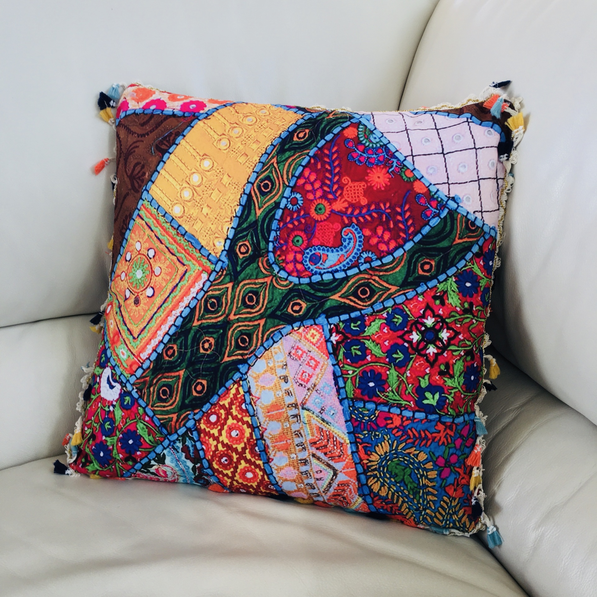 Almofada patchwork colorida com padrões variados num sofá bege