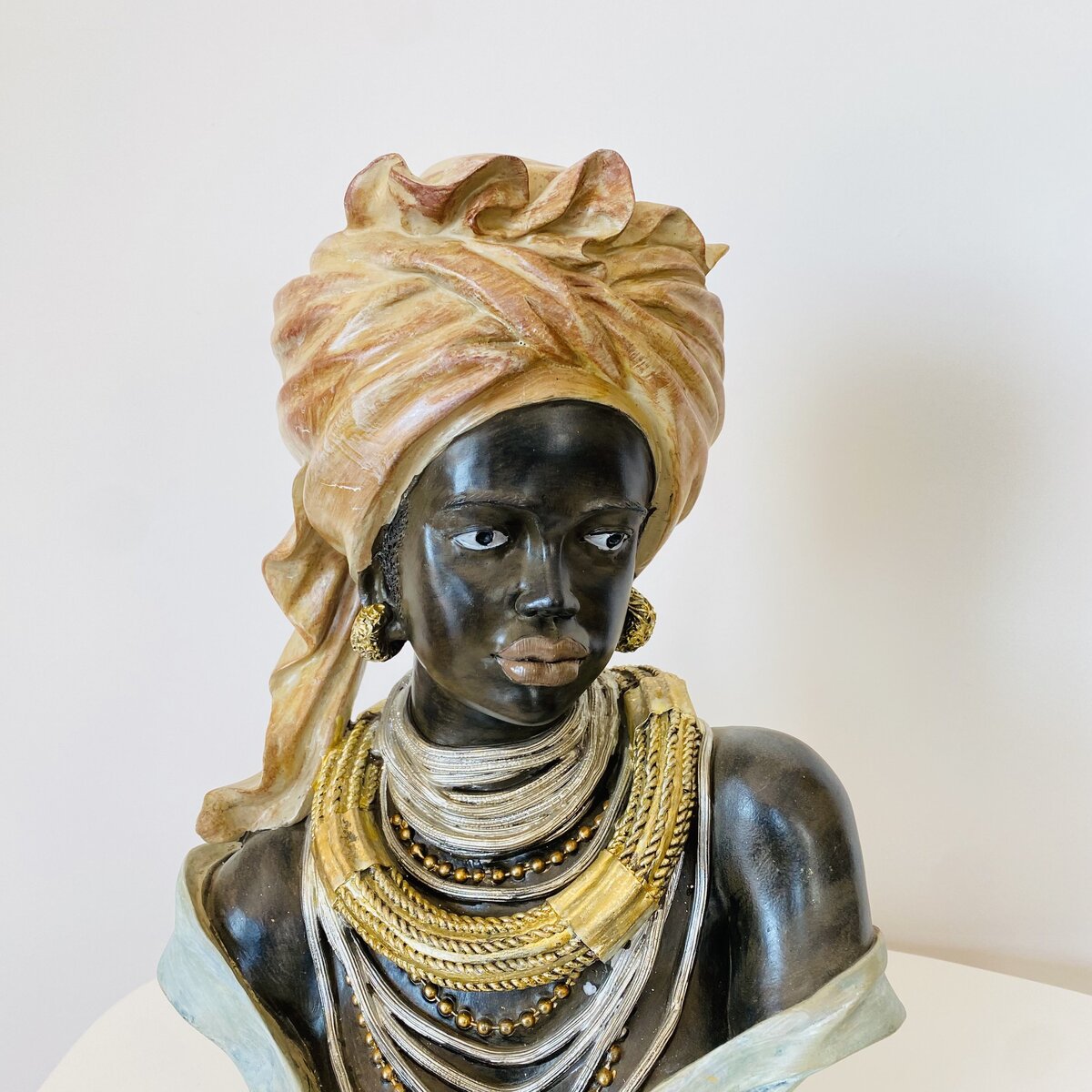Busto decorativo de mulher negra com turbante e colares