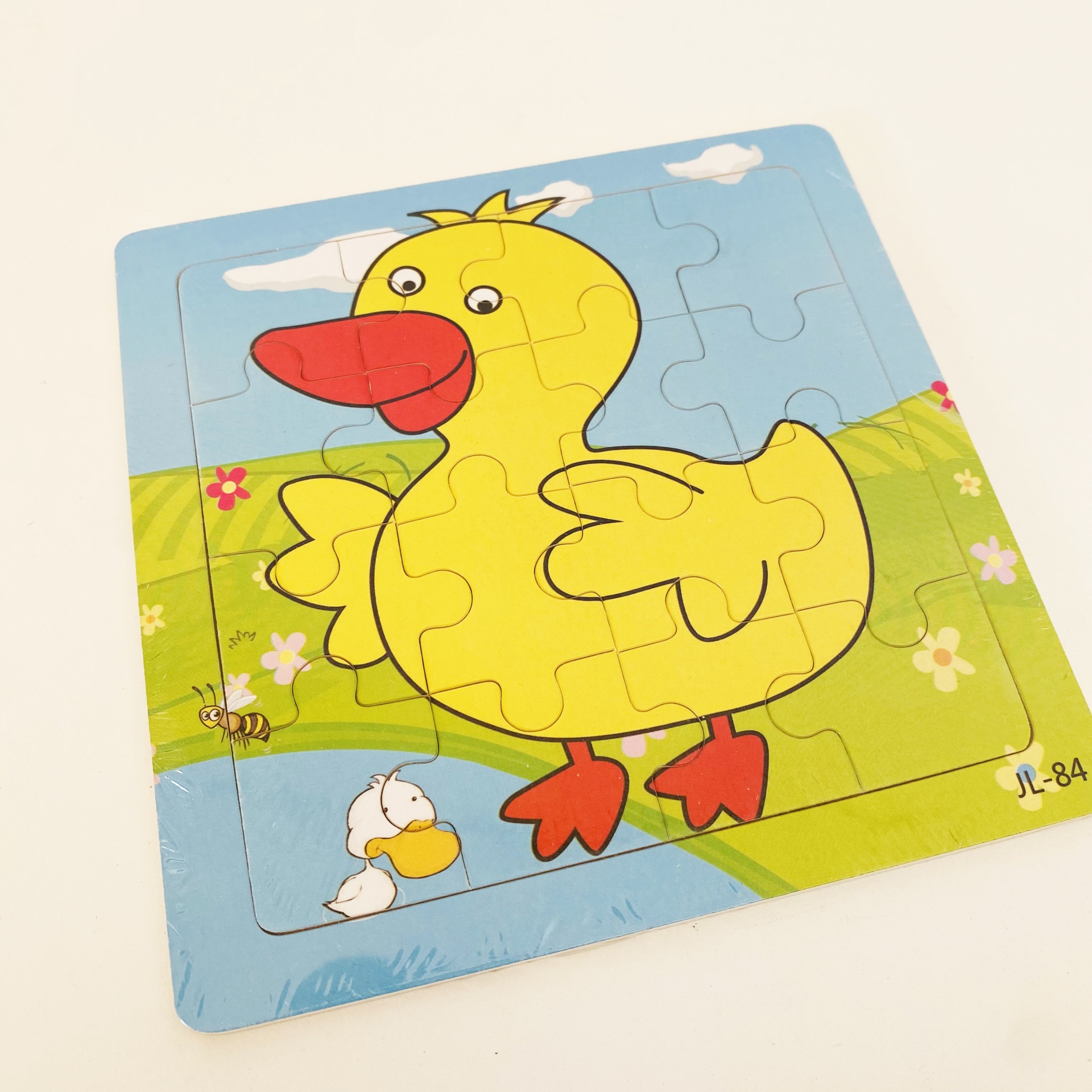Quebra-cabeças infantil com imagem de pato amarelo e fundo azul e verde
