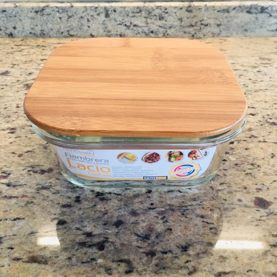 Recipiente quadrado em vidro com tampa de madeira clara sobre bancada de granito