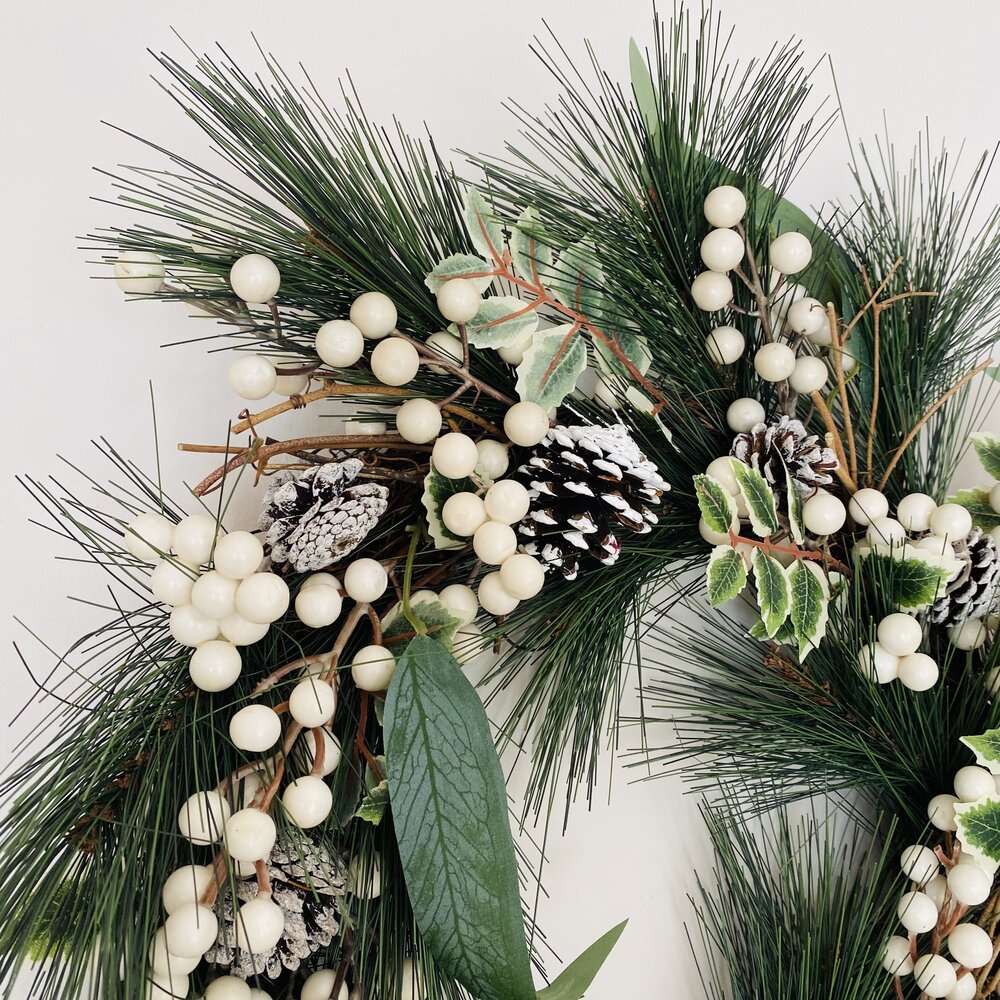 Ramos decorativos de pinheiro com bagas brancas e pinhas pintadas de branco