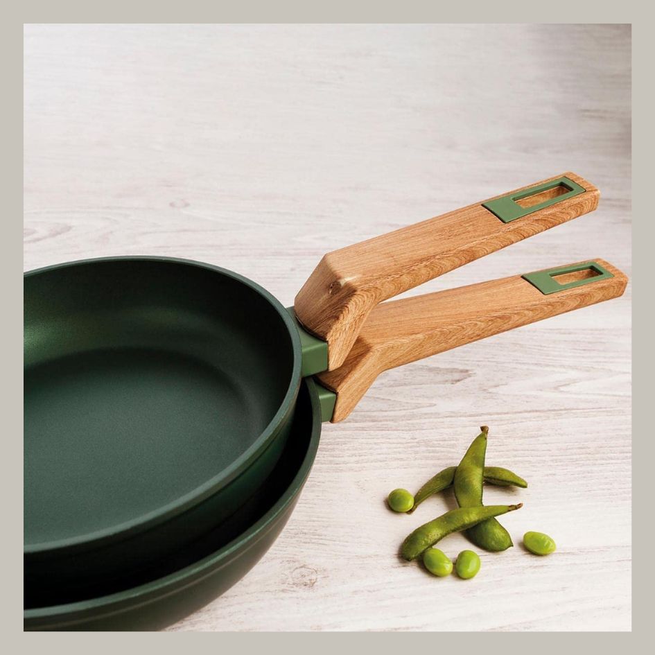 Duas frigideiras verdes com cabos de madeira e vagens verdes ao lado