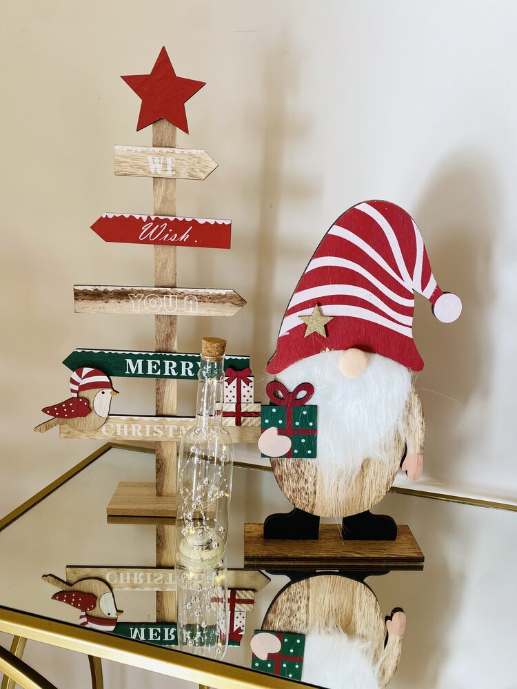 Decoração de Natal em madeira com estrela vermelha, setas coloridas, gnomo com chapéu vermelho e branco e frasco de vidro com luzes
