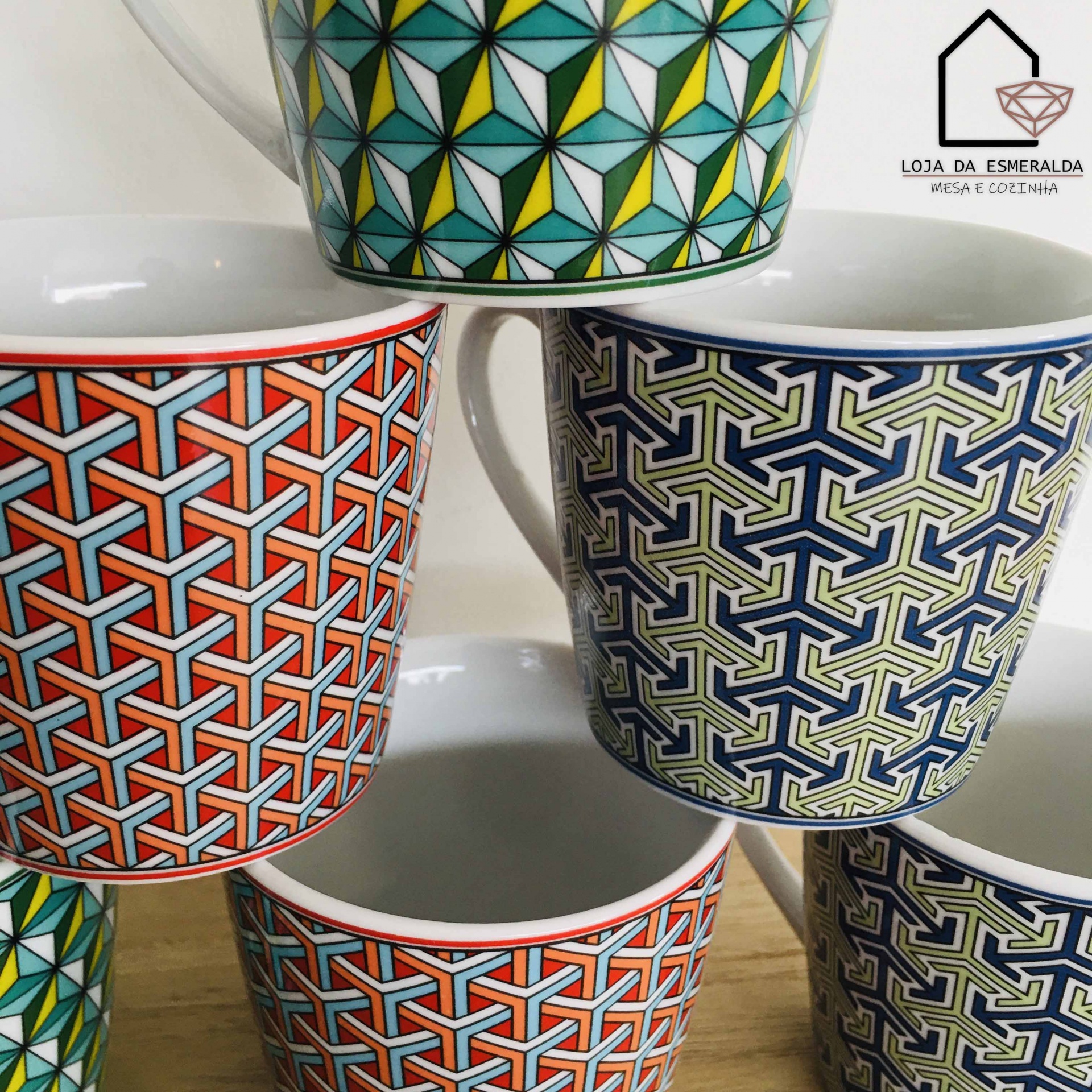 Canecas coloridas com padrões geométricos em suporte branco sobre superfície de madeira
