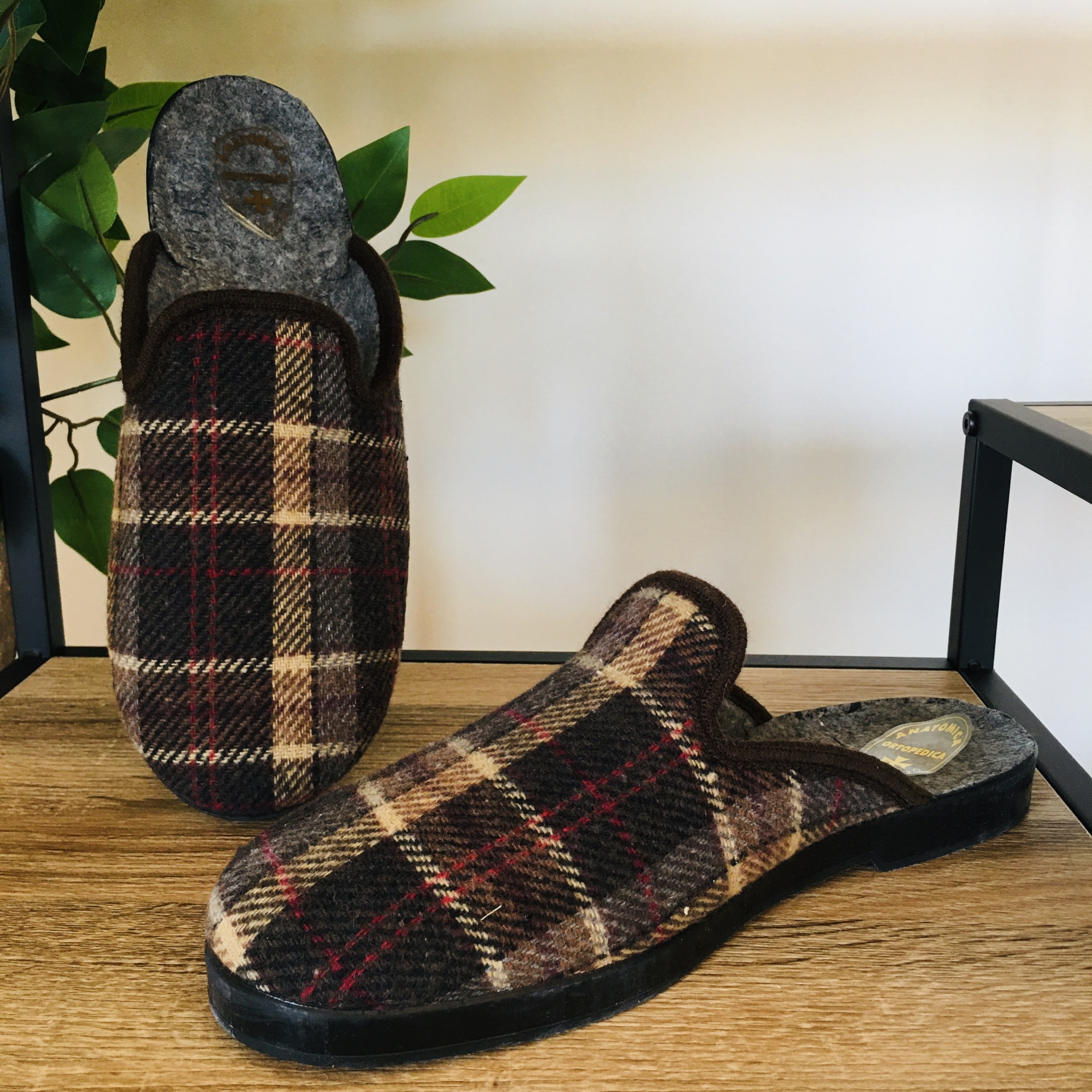 Chinelos masculinos padrão xadrez castanho, bege, vermelho, preto sobre prateleira de madeira