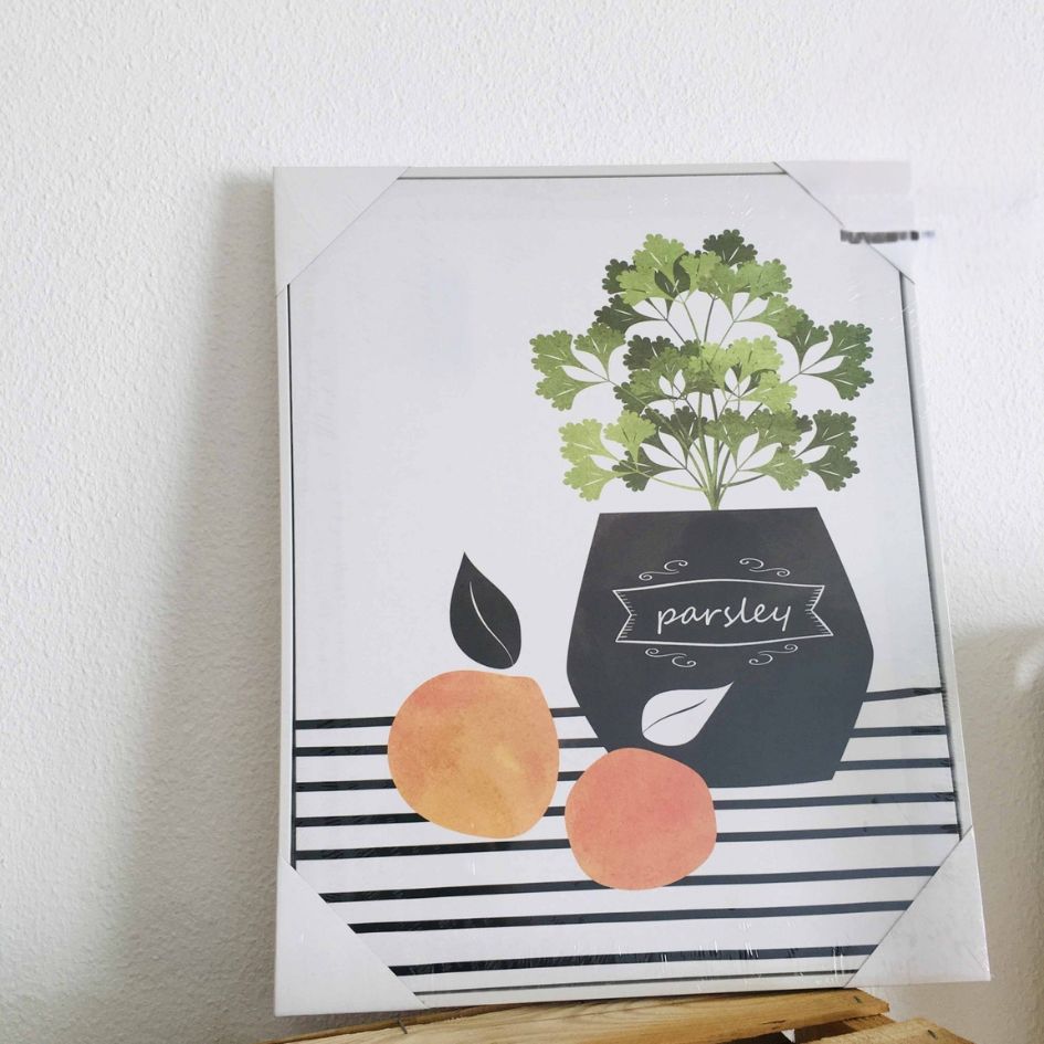 Quadro decorativo com vaso preto e salsa verde e frutas laranjas