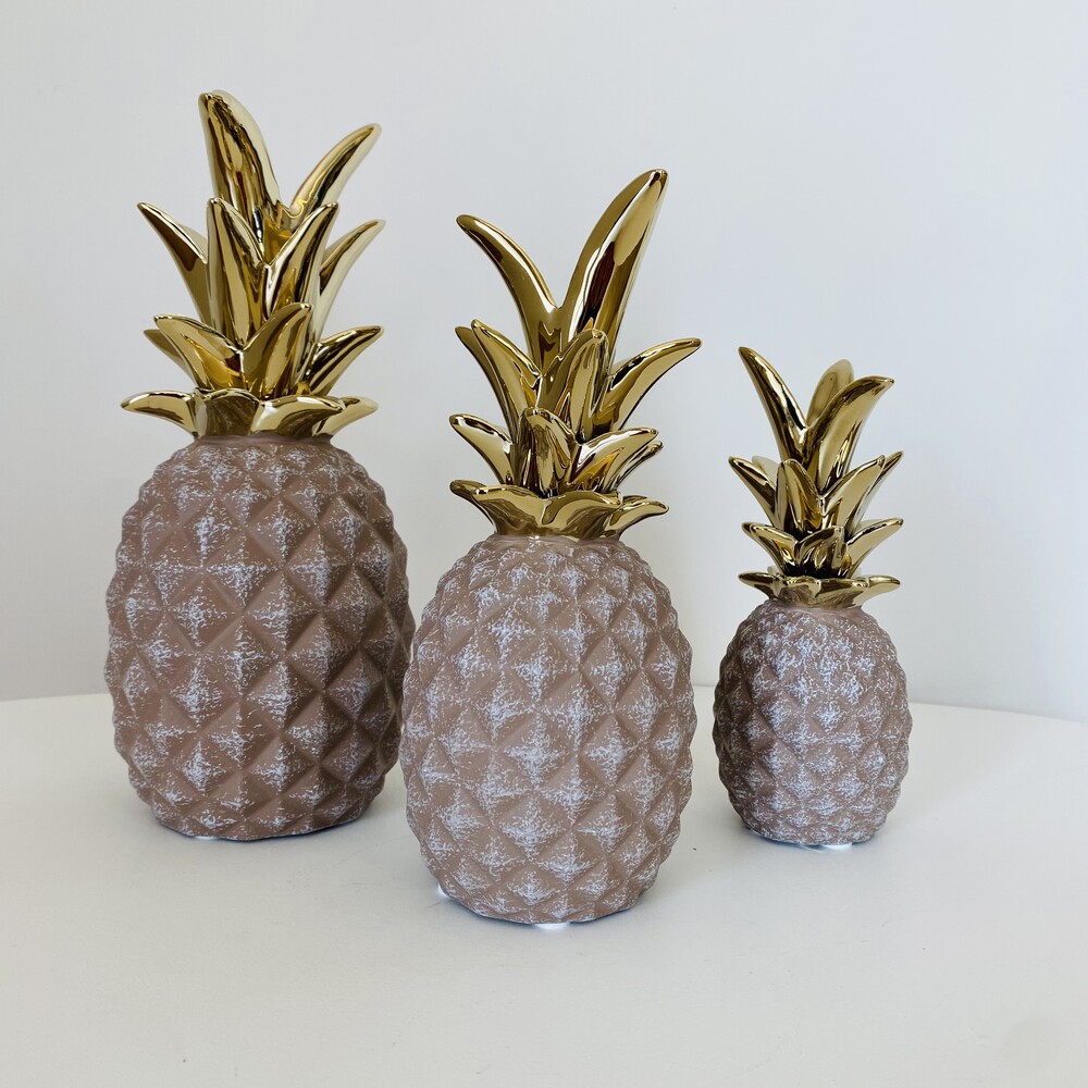 Três figuras decorativas de ananás castanho com folhas douradas