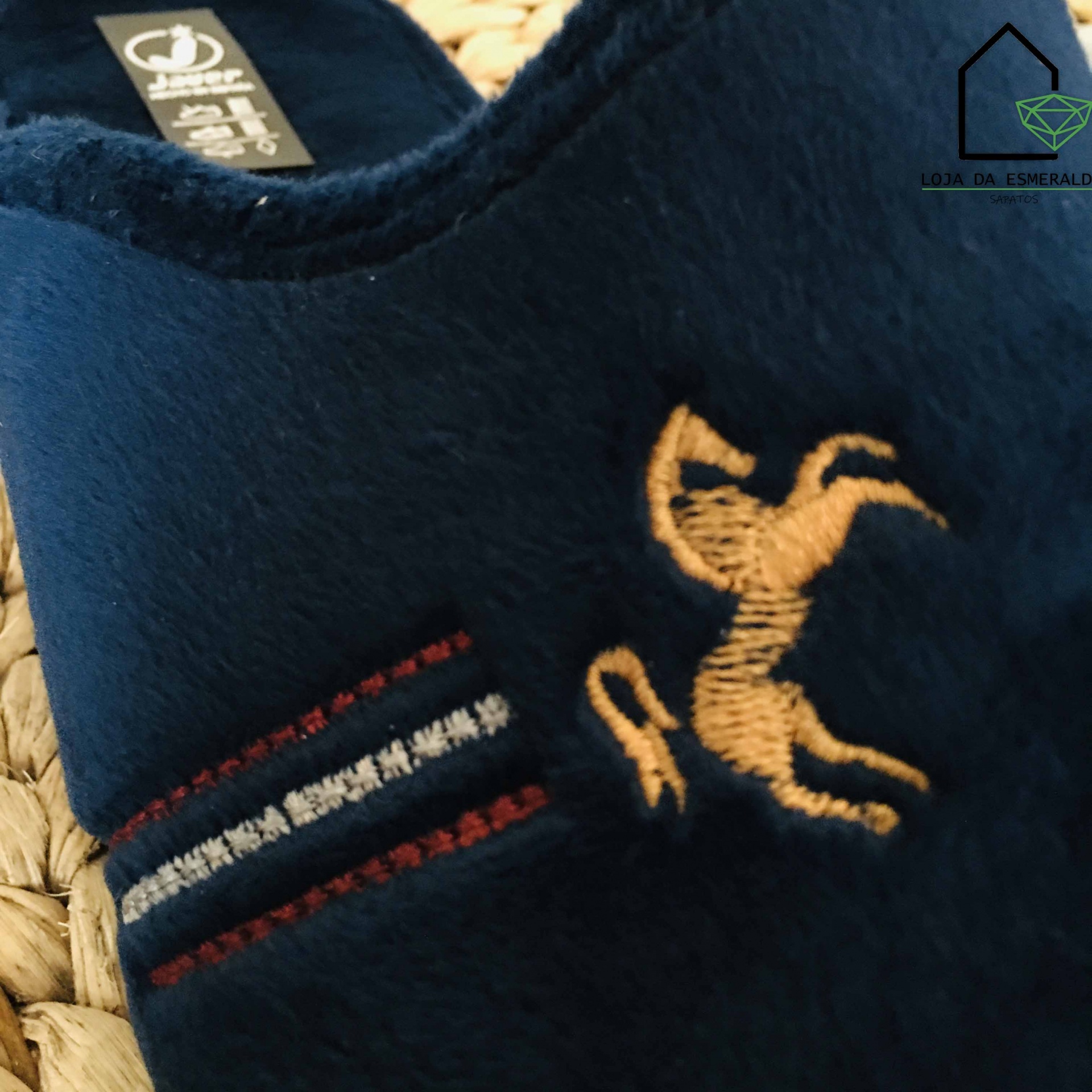 Pantufa azul escura com bordado de cavalo bege e riscas vermelhas e brancas