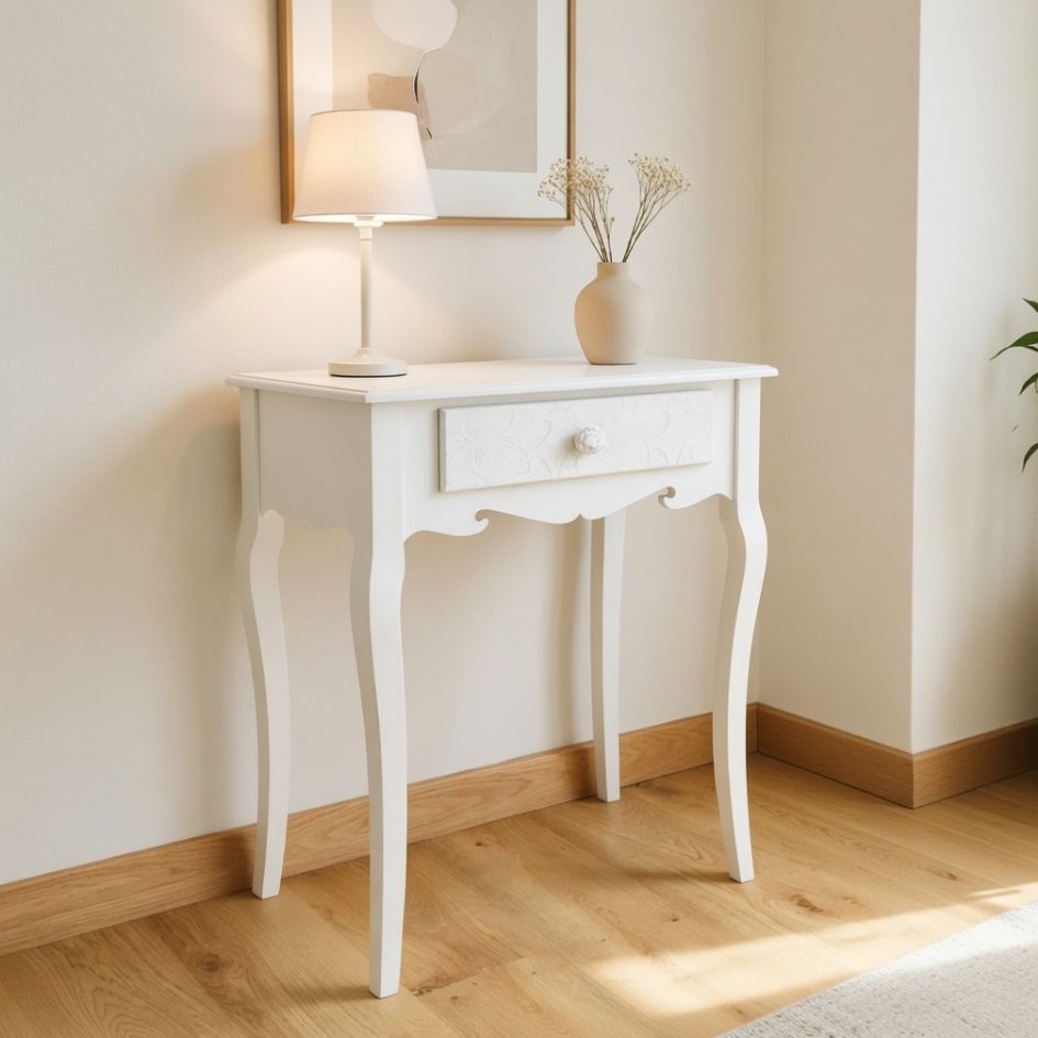 Mesa de apoio branca com gaveta e pernas curvas, abajur branco e vaso de cerâmica com flores secas