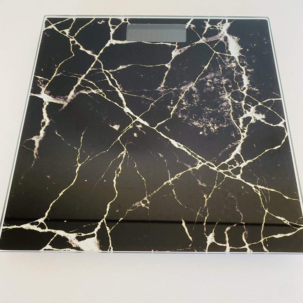 Balança digital com design preto marmoreado com veios brancos e dourados