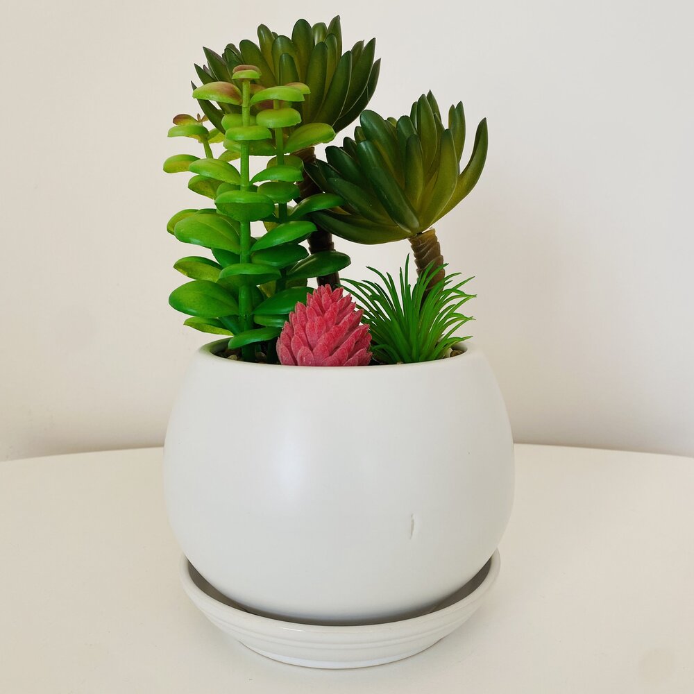 Vaso branco com plantas suculentas artificiais em tons de verde e rosa