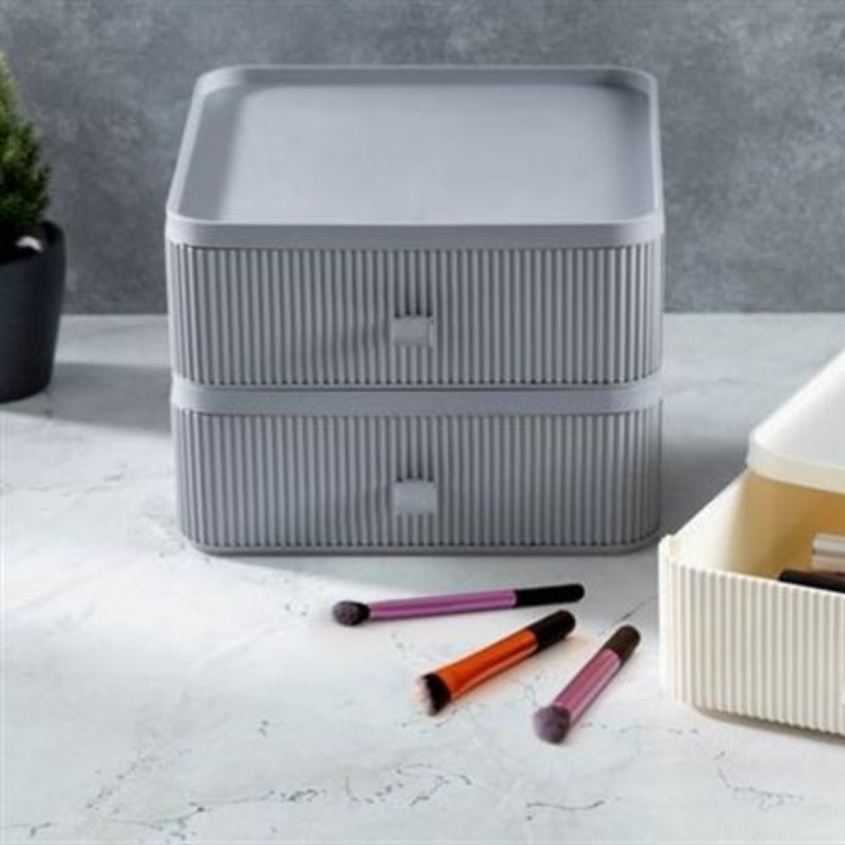 Caixas de armazenamento cinzentas e creme com pincéis de maquilhagem