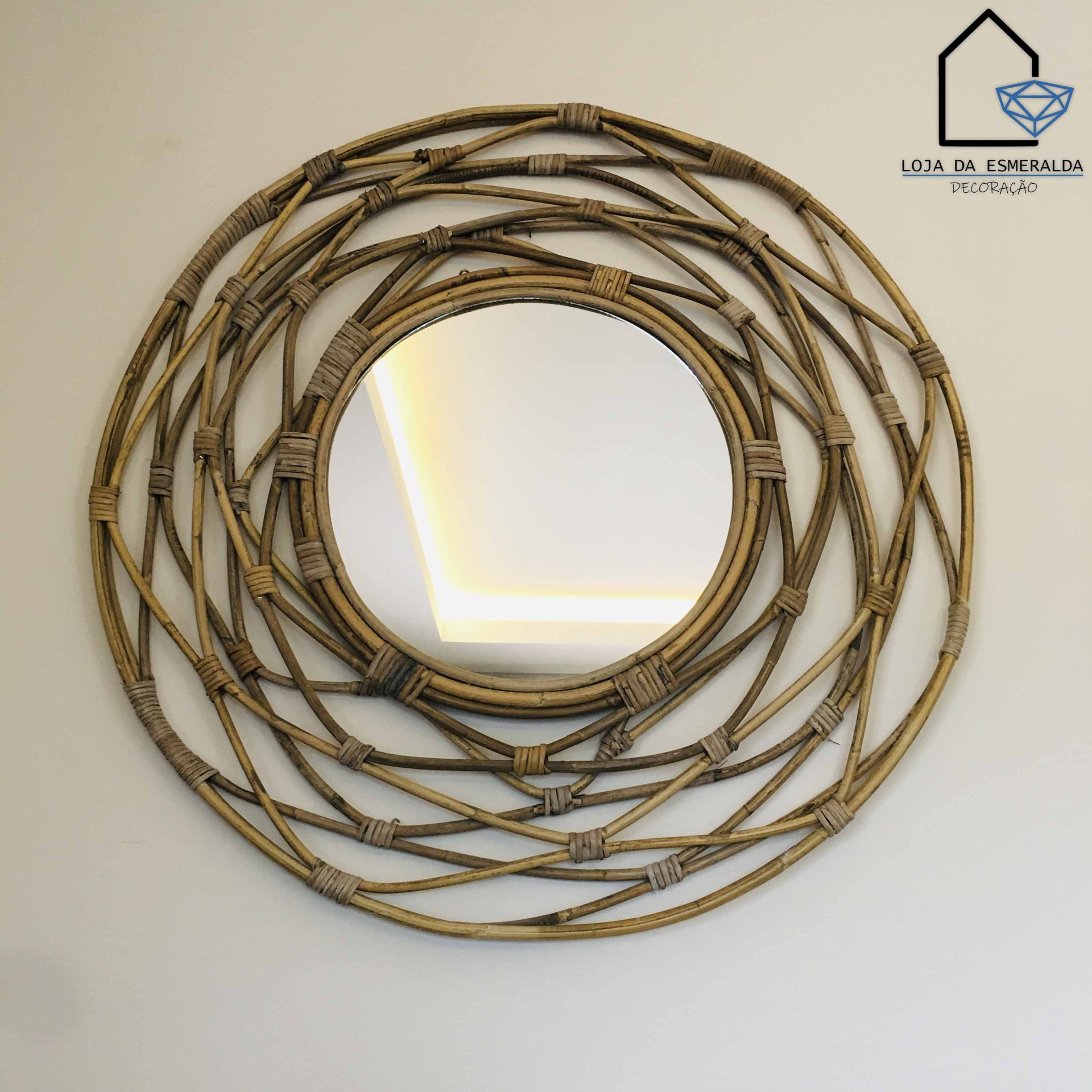 Espelho redondo com moldura em rattan trançado na parede branca