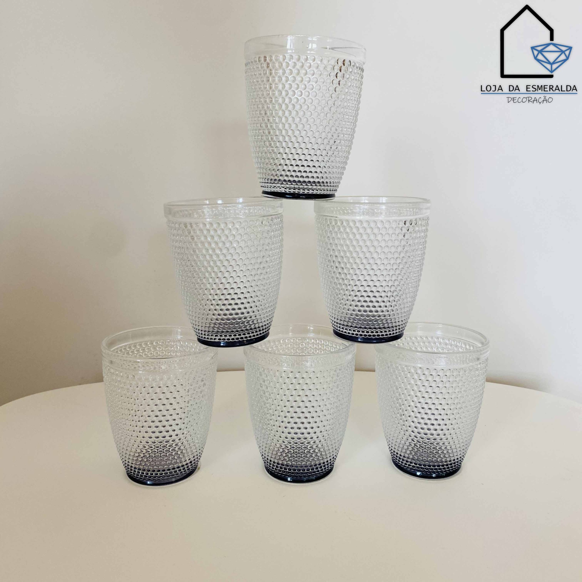 Conjunto de seis copos de vidro texturizados transparents com base azul escuro.