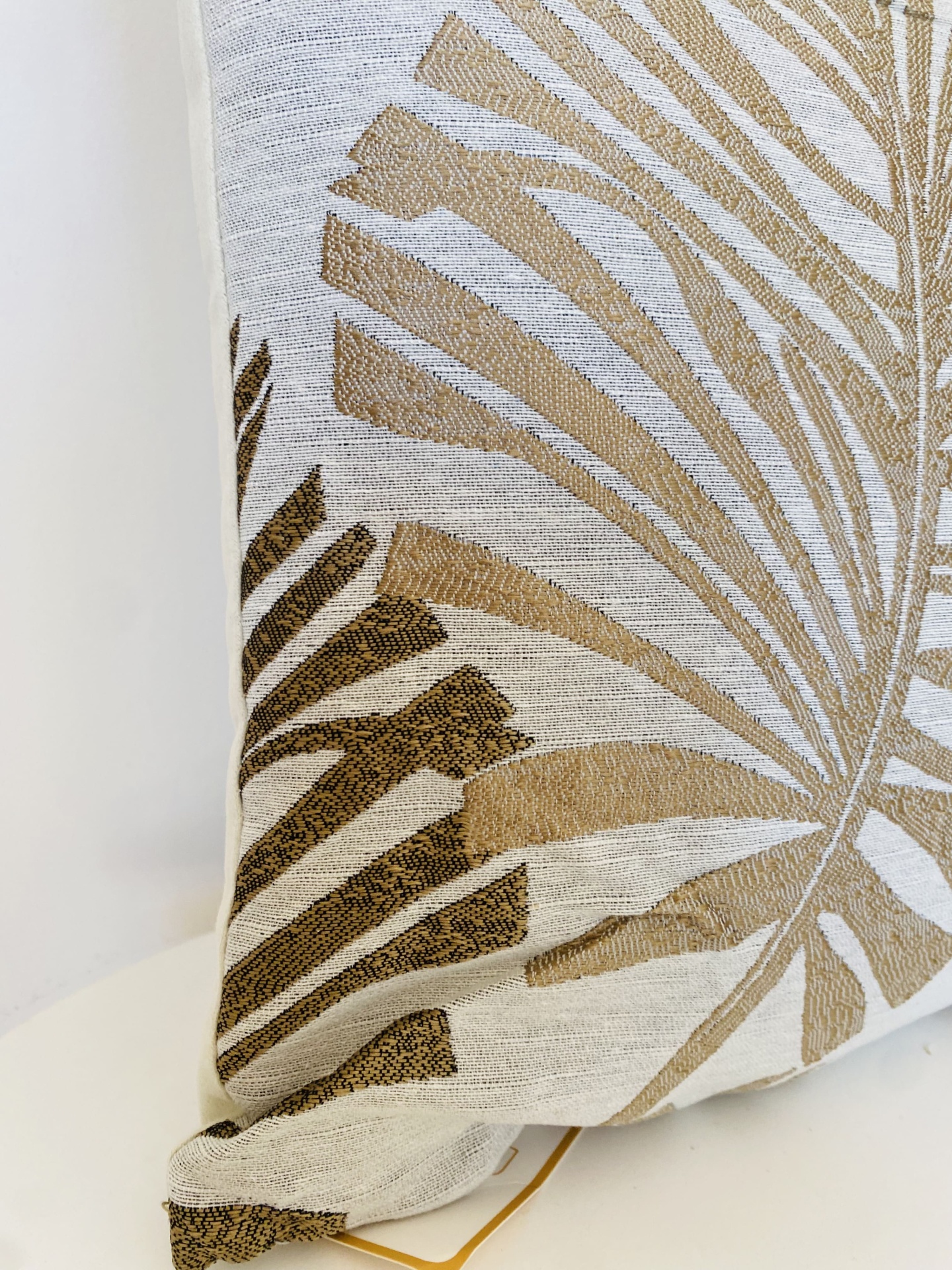 Almofada decorativa bege com padrão de folhas castanhas