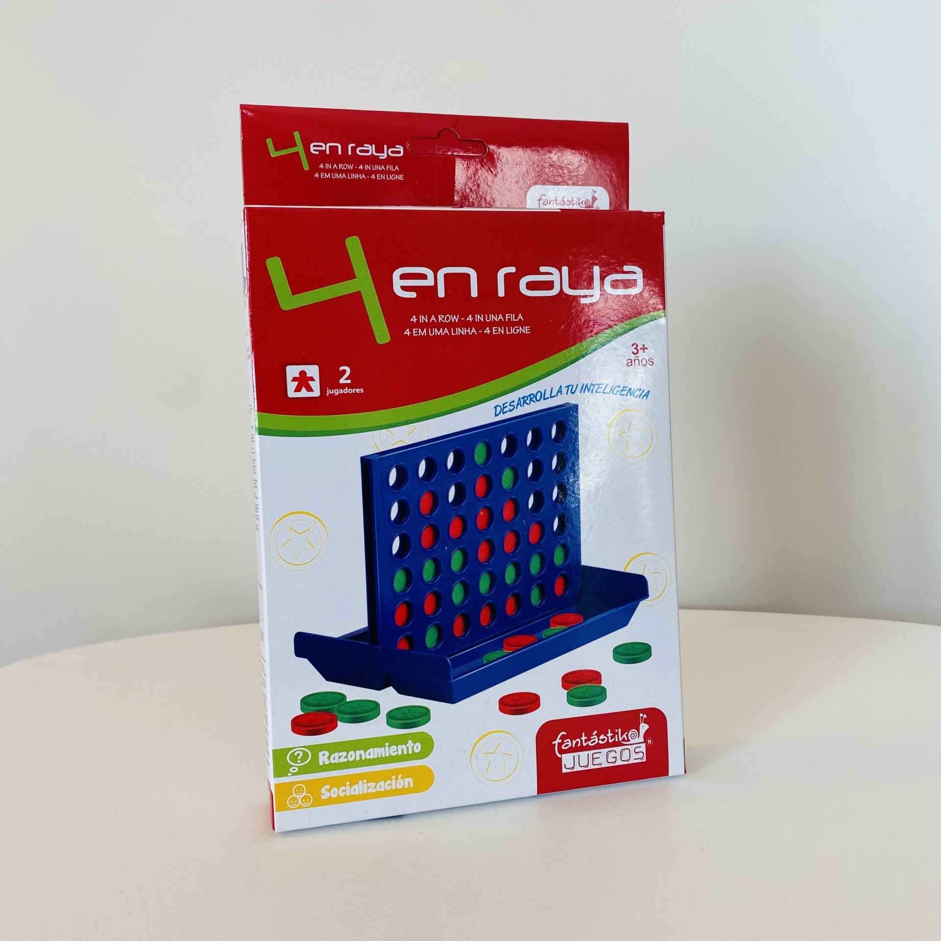 Embalagem do jogo 4 en raya com peças coloridas e texto em espanhol.