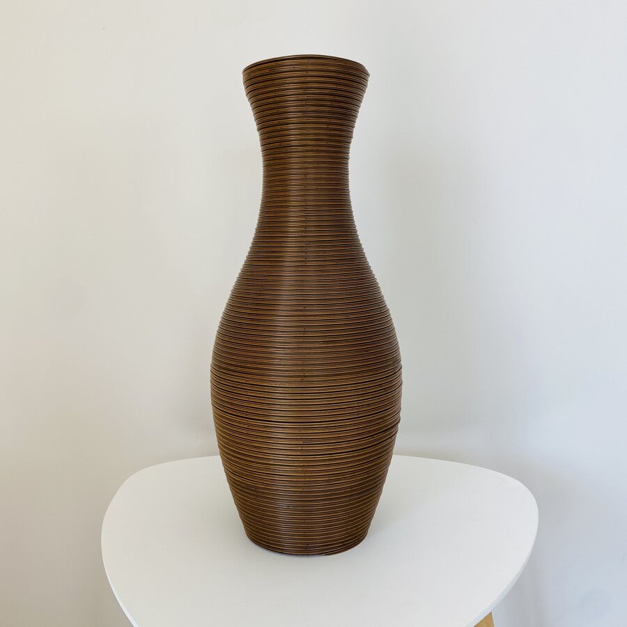 Vaso de madeira castanho com textura de listras sobre mesa branca