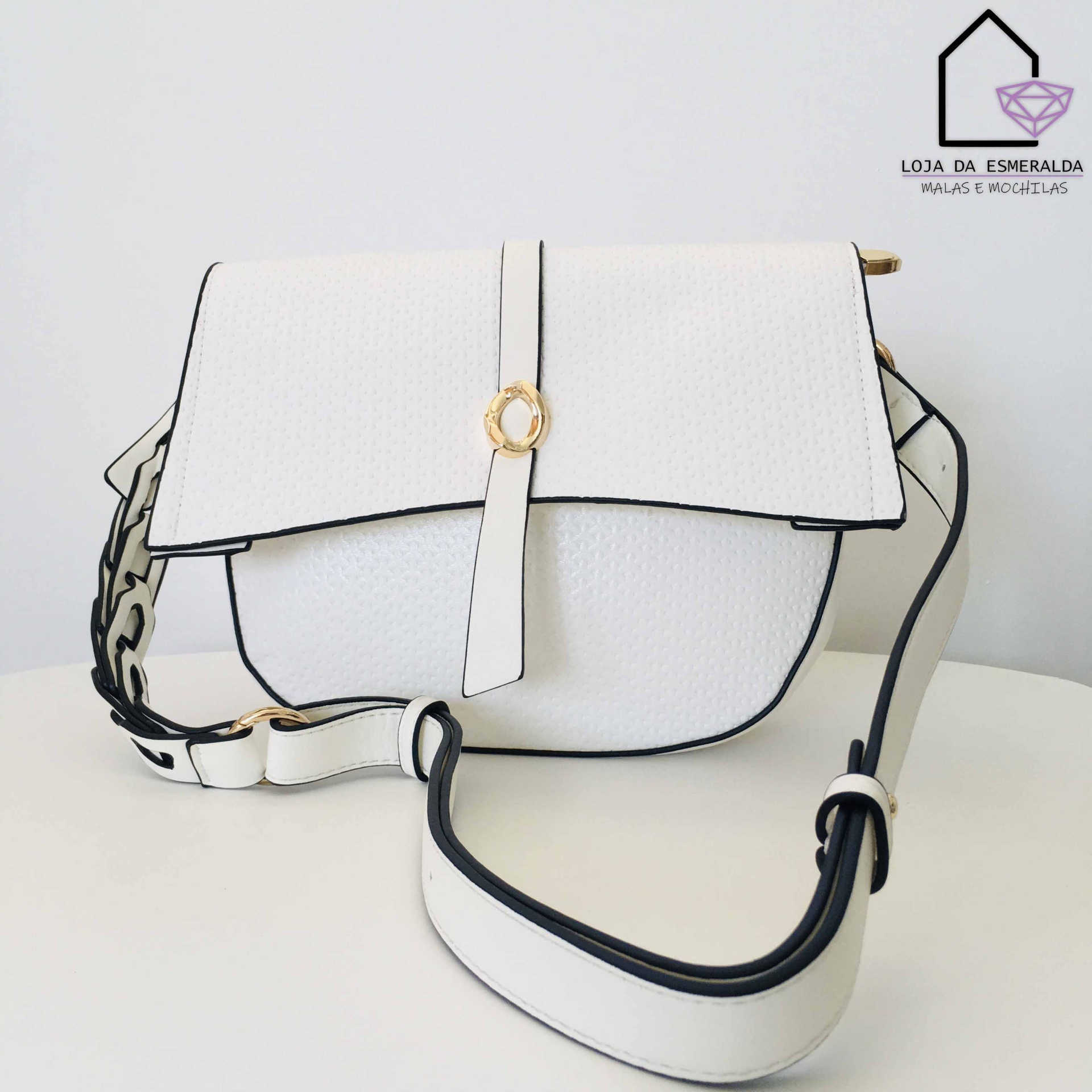 Mala branca em pele com fecho em aba e alça larga ajustável sobre superfície branca