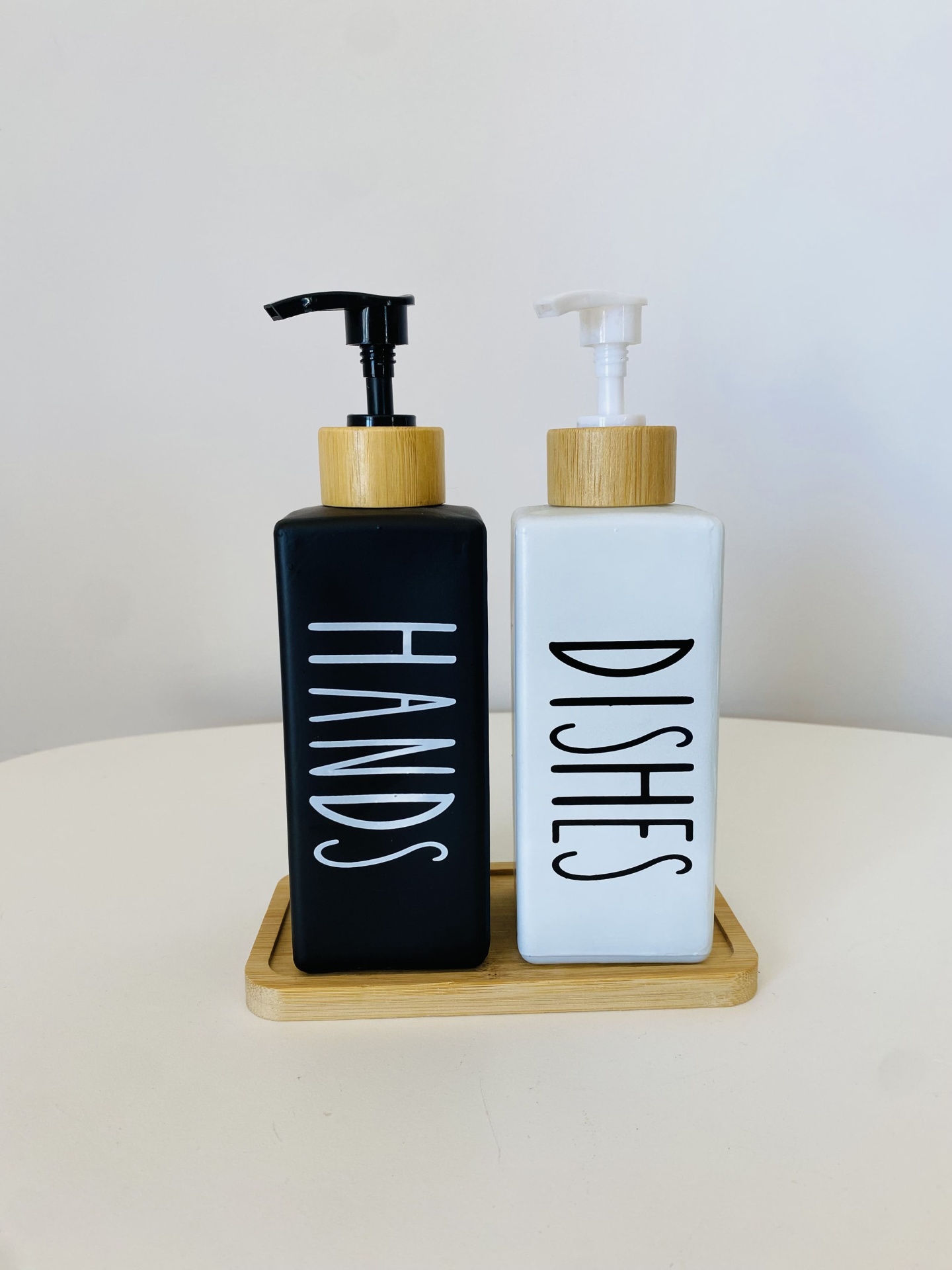 Conjunto de dispensadores pretos e brancos com tampas e base de madeira