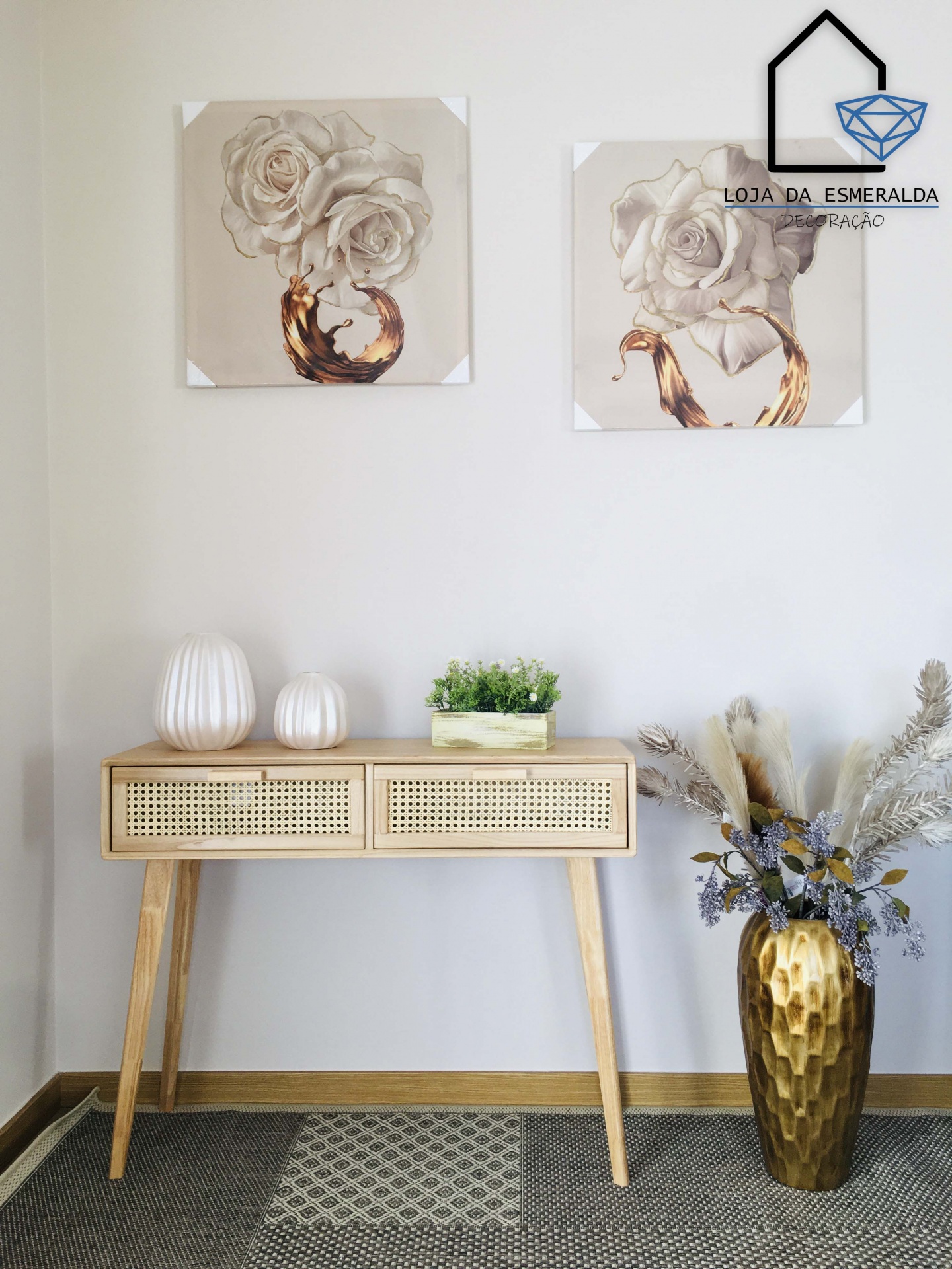 Conjunto de mesa em madeira clara com decoração minimalista e quadros de flores na parede branca