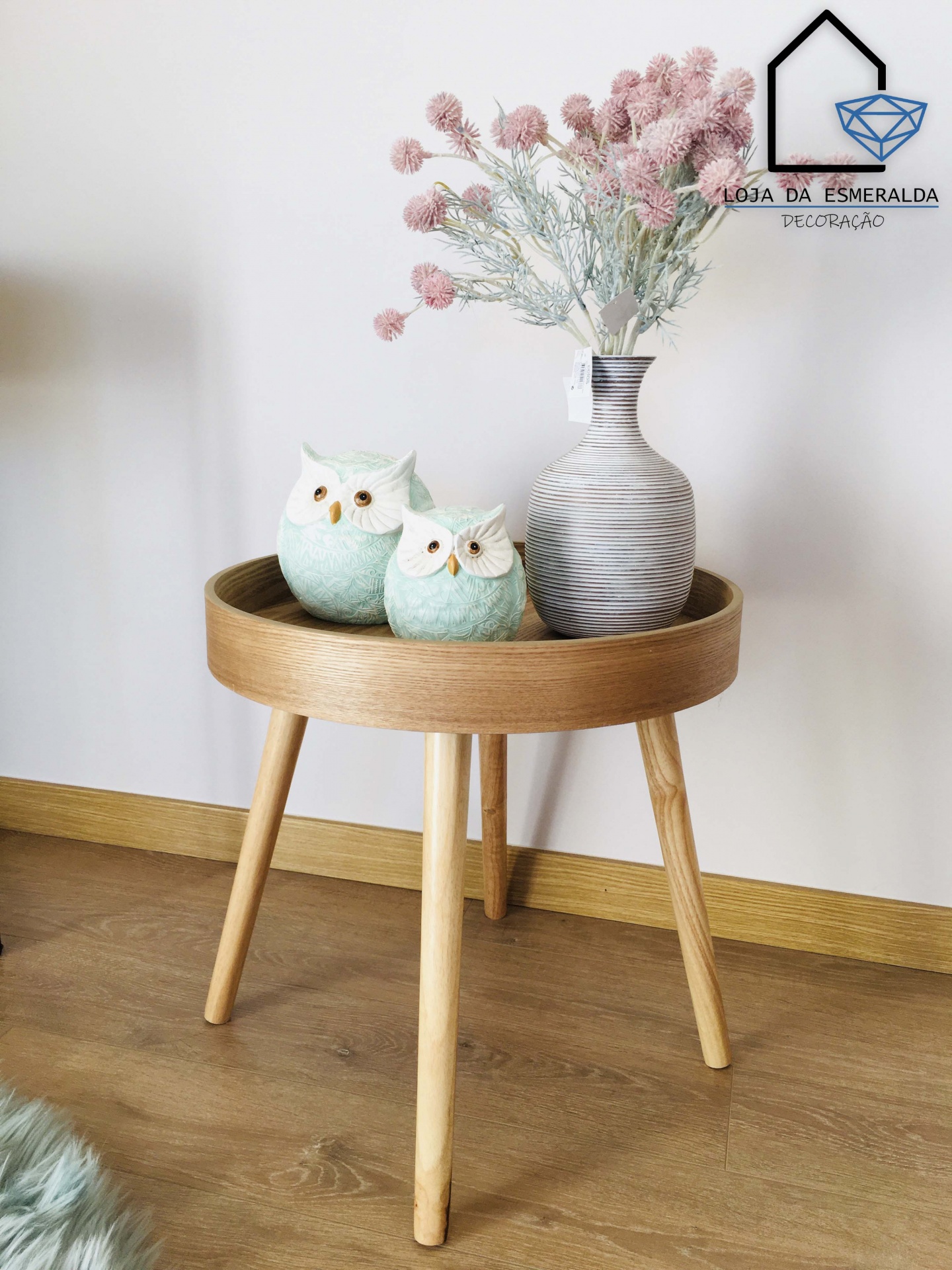 Mesa auxiliar redonda de madeira clara com vaso e duas corujas decorativas