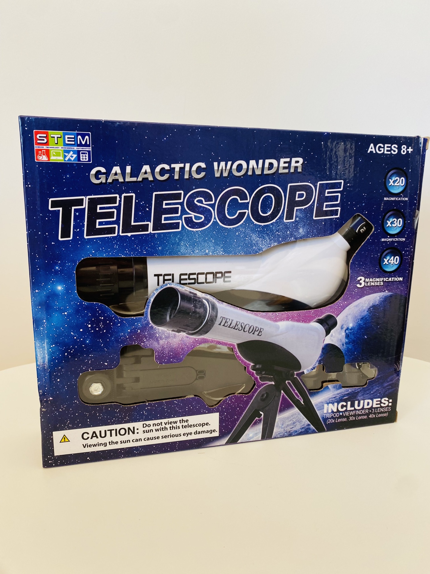 Caixa azul estrelada com telescópio branco e preto e informações do produto