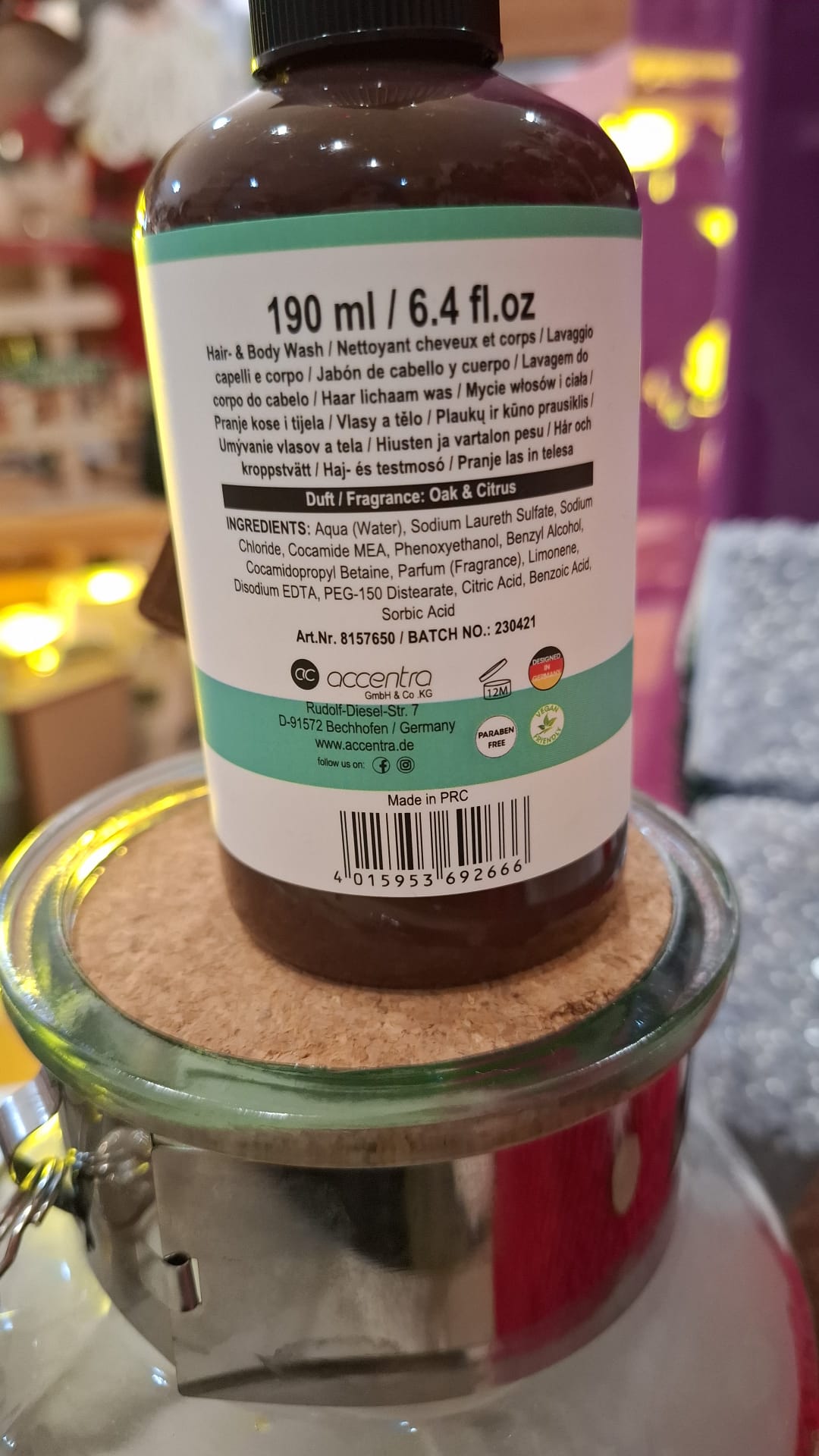 Frasco castanho de gel de banho e cabelo com rótulo branco e verde