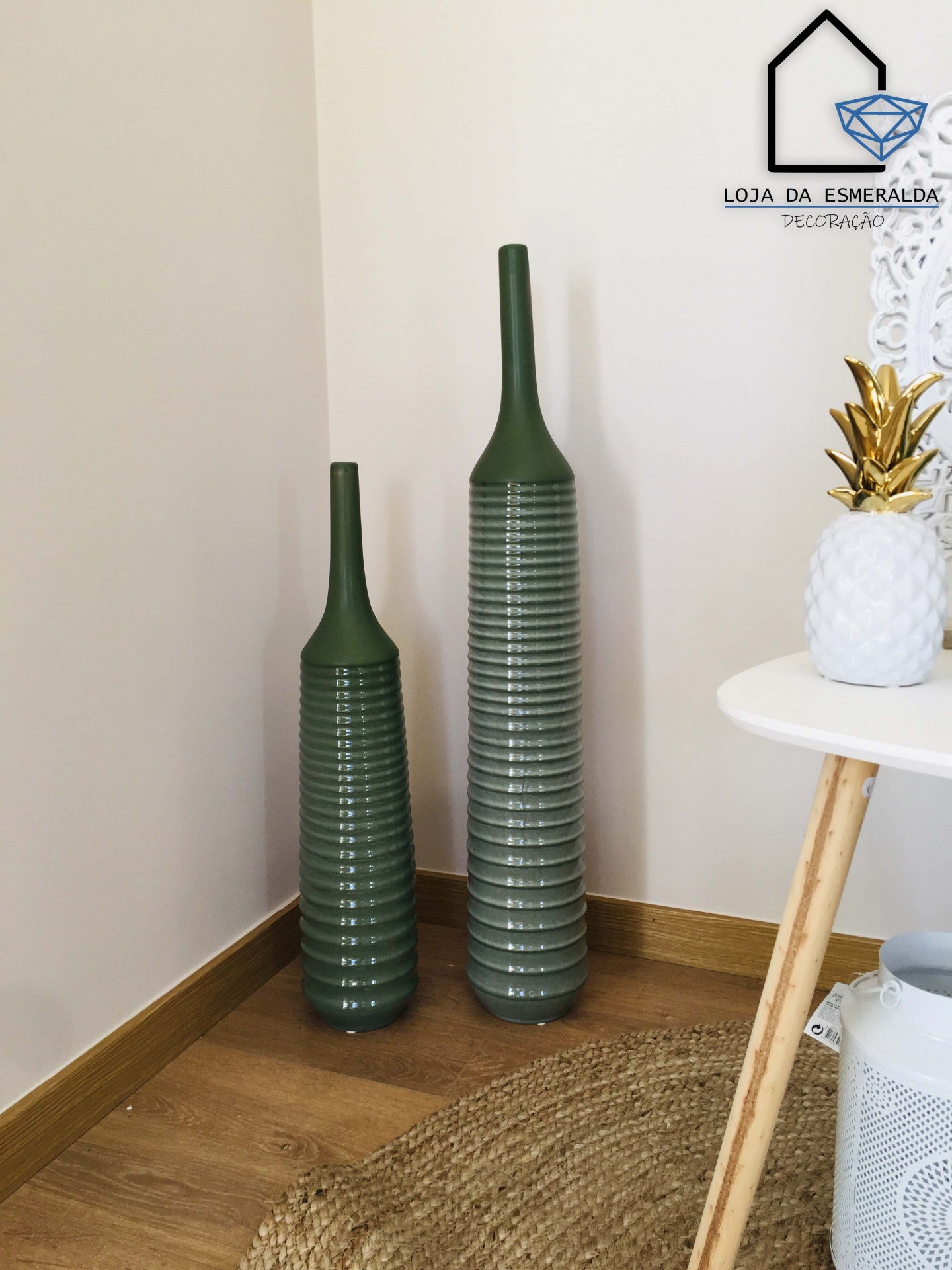 Dois vasos verdes altos com textura de anéis em canto interior e decoração adjacente