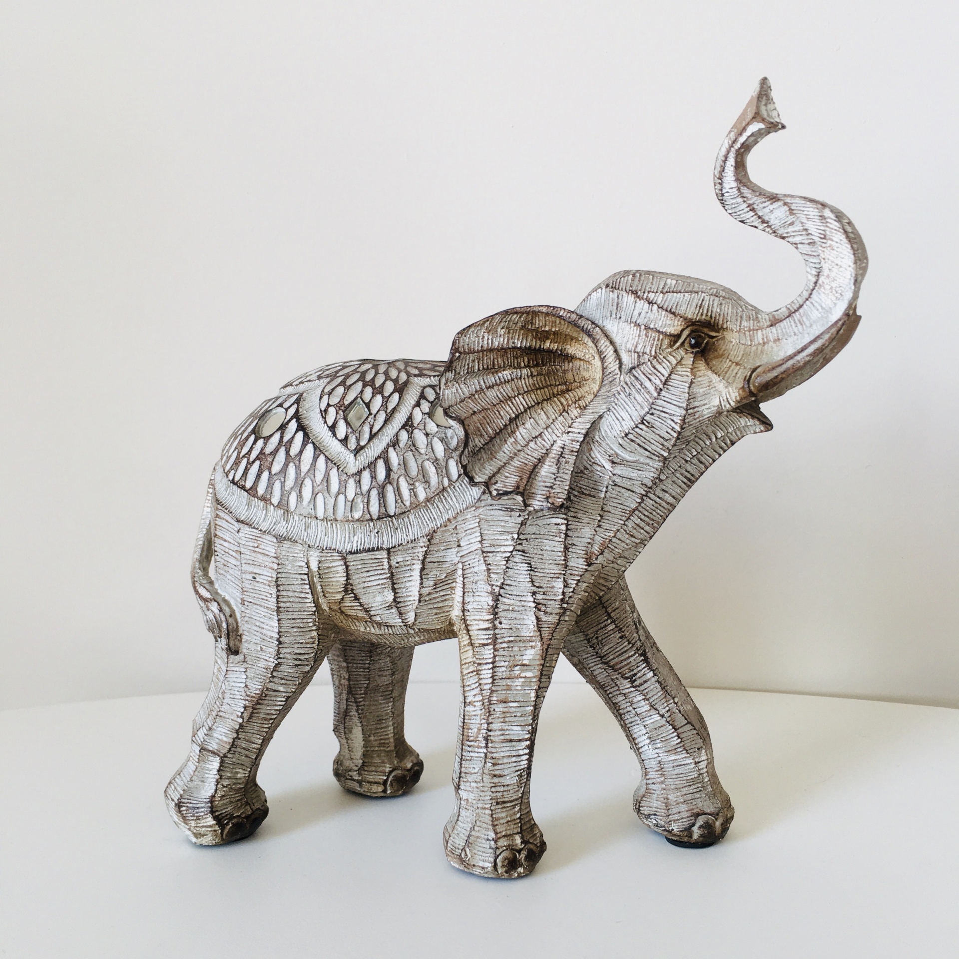 Escultura de elefante decorativa em branco e castanho com detalhes texturizados
