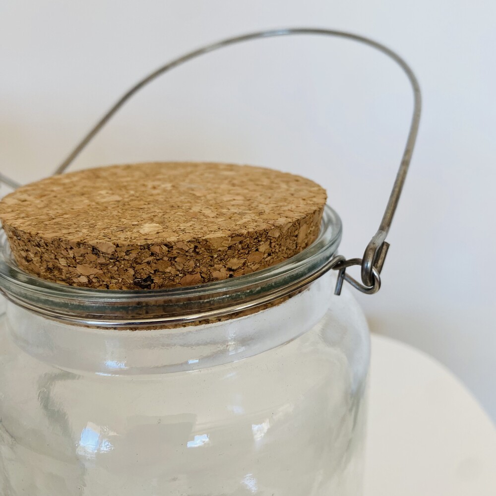 Frasco de vidro com tampa de cortiça e alça metálica